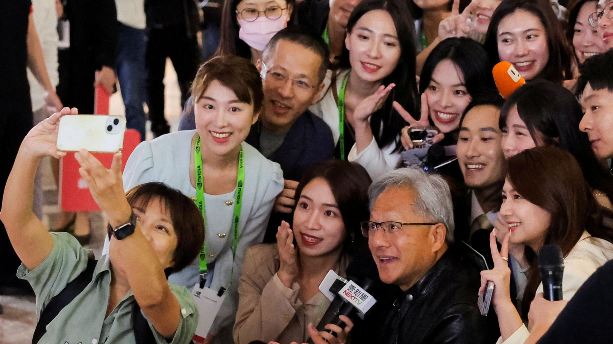Nvidia CEO Jensen Huang poses for a selfie with members of the media at COMPUTEX forum in Taipei.