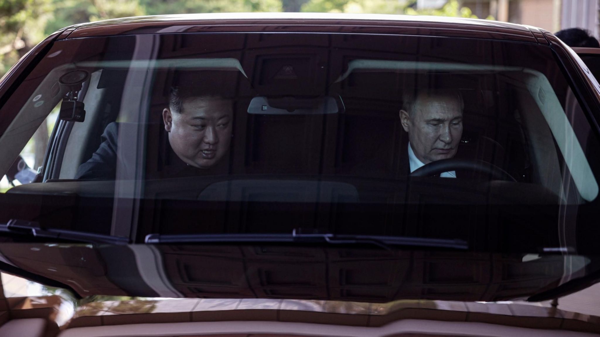 North Korean leader Kim Jong Un (left) and Russian President Vladimir Putin ride an Aurus car in Pyongyang