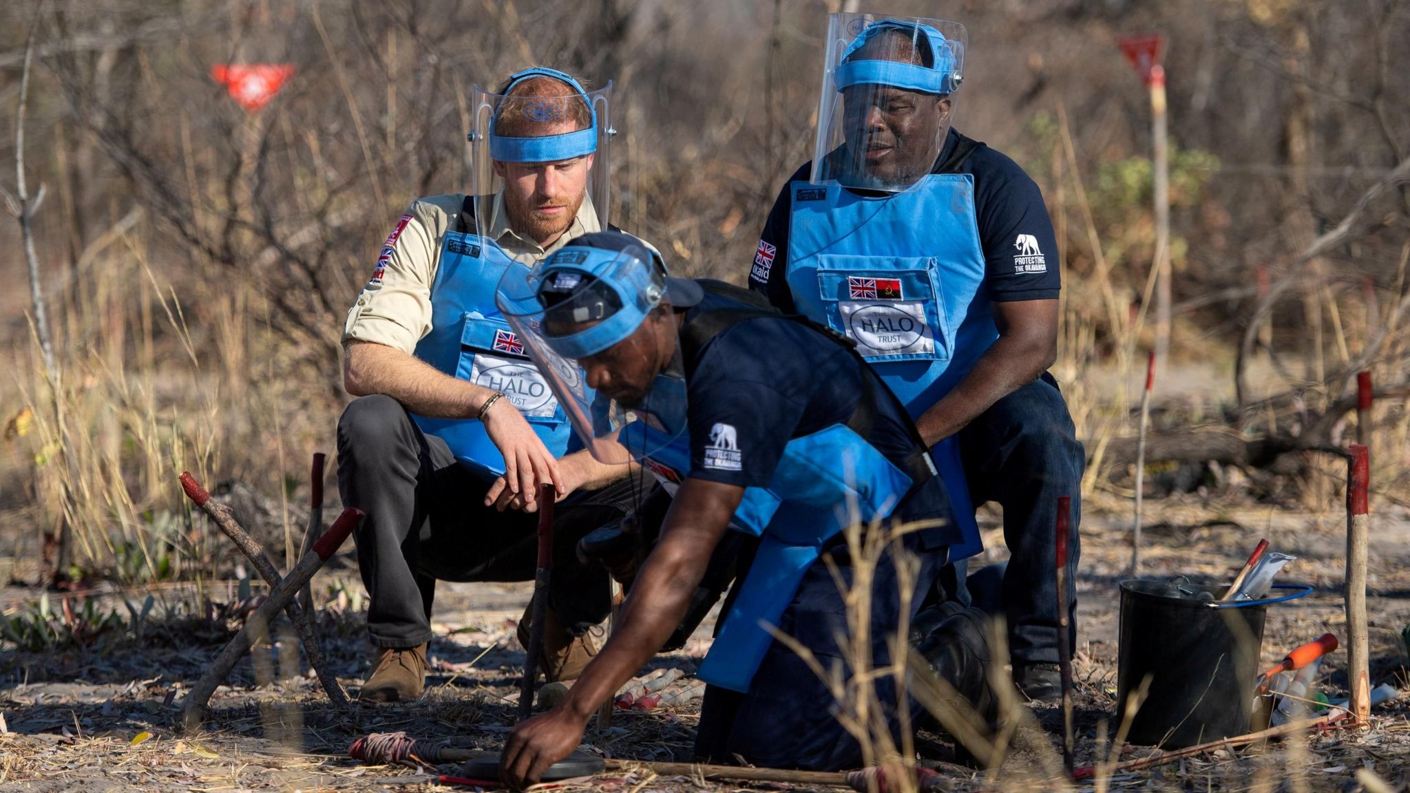 Britain's Prince Harry, Duke of Sussex, and Halo Regional Manager Jose Antonio watch as Mine Clearer Jorge Joao Cativa demonstrates mine clearing techniques during his visit to a working de-mining field with the HALO Trust in Dirico Province, Angola, September 27, 2019.