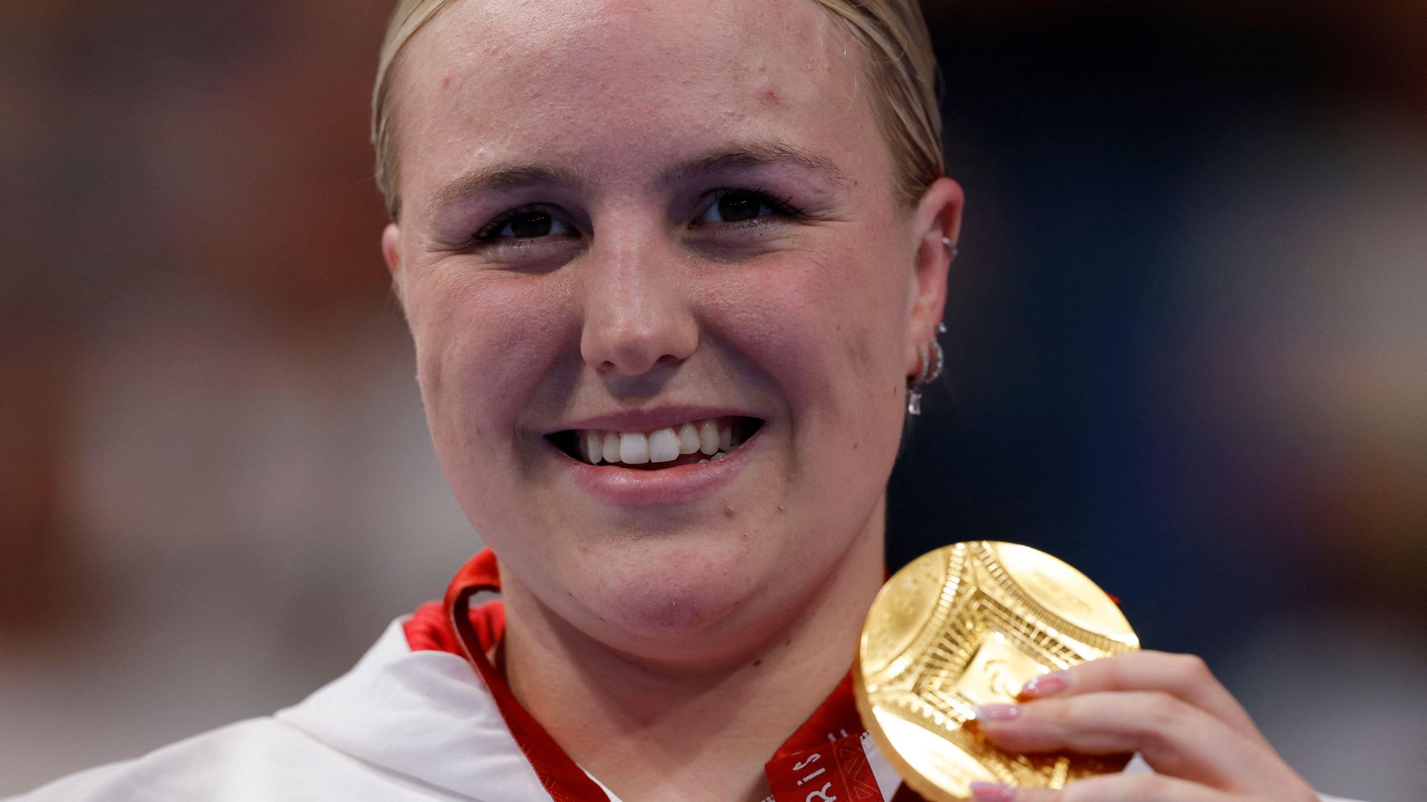 Faye Rogers holds up her Paralympic gold medal