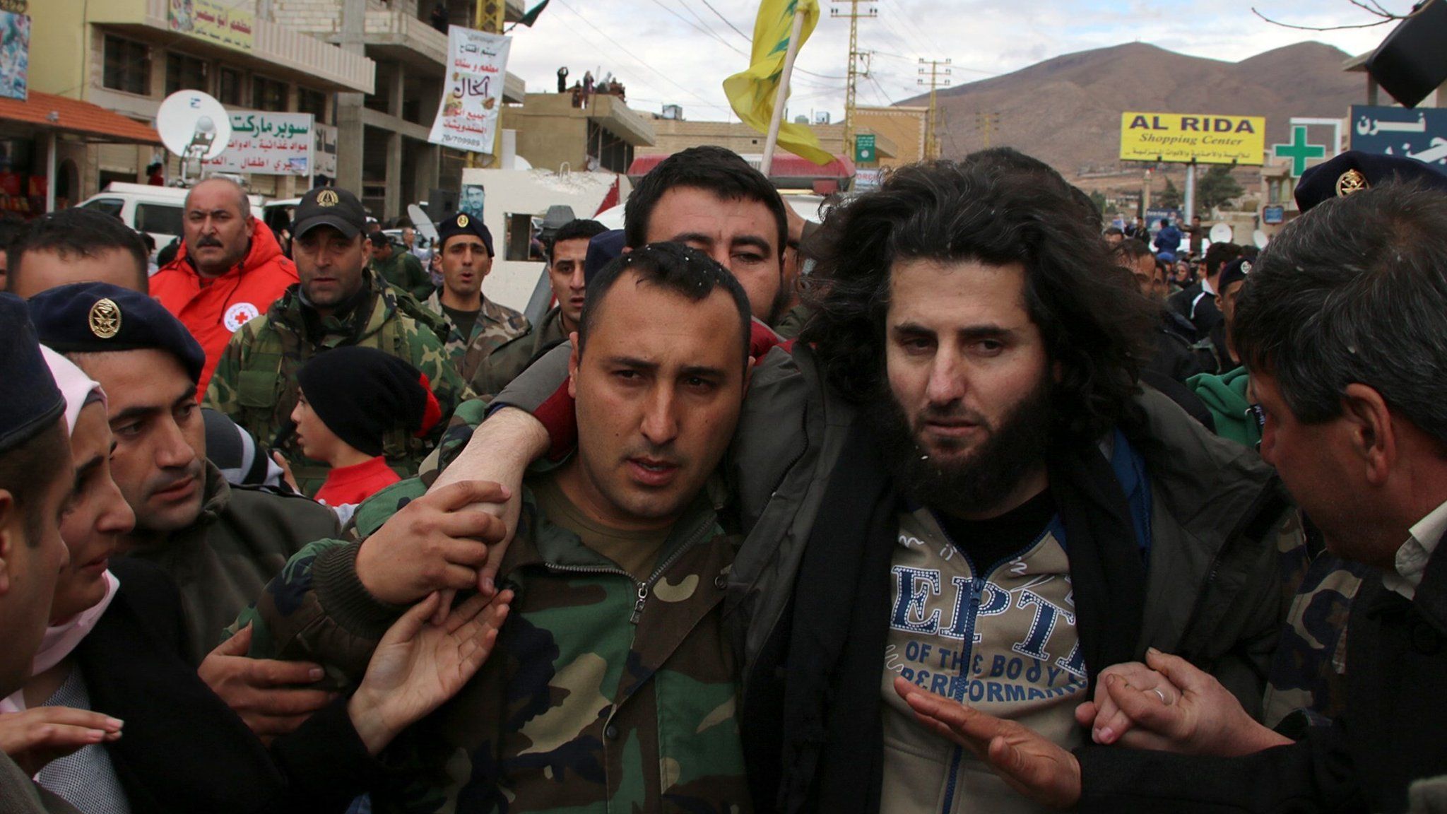 A Lebanese soldier helps a fellow member of the security forces held captive by al-Nusra Front moments after his release on 1 December 2015, in the village of Labweh, Lebanon