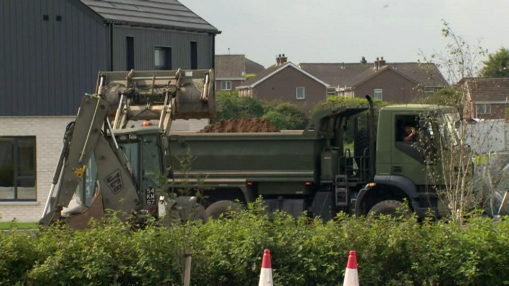 Digger loading sand into a flat bed truck in the Rivenwood housing development 