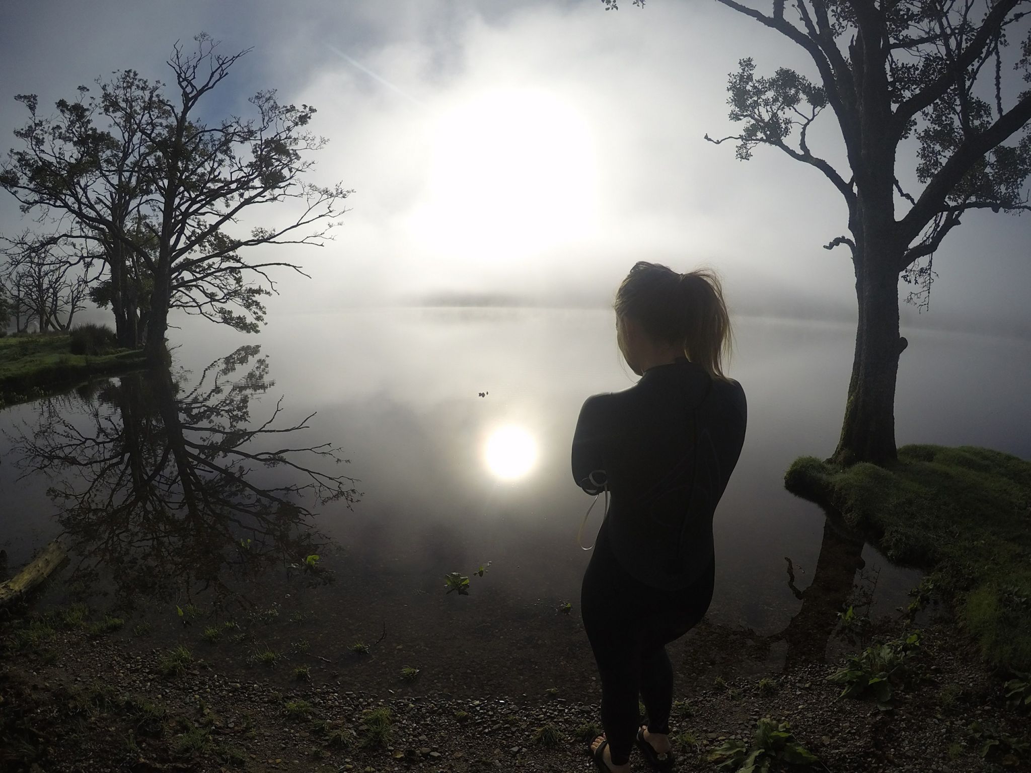 Woman about to swim in misty loch