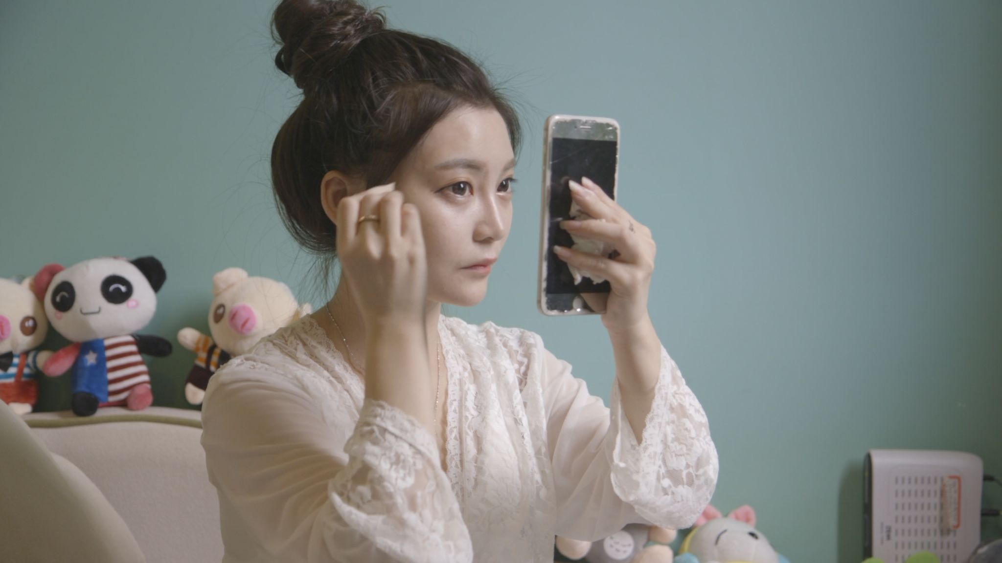 Lele Tao puts on make-up in her night gown.