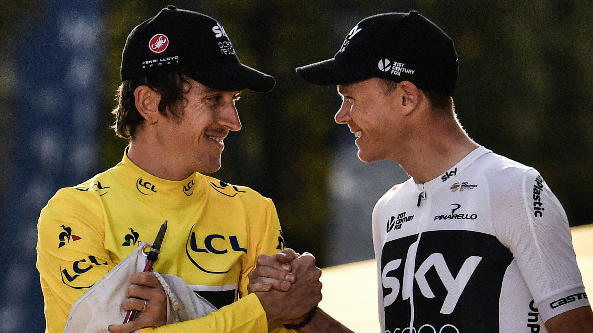 Tour de France champion Geraint Thomas and Chris Froome clasp hands in celebration on the podium in Paris