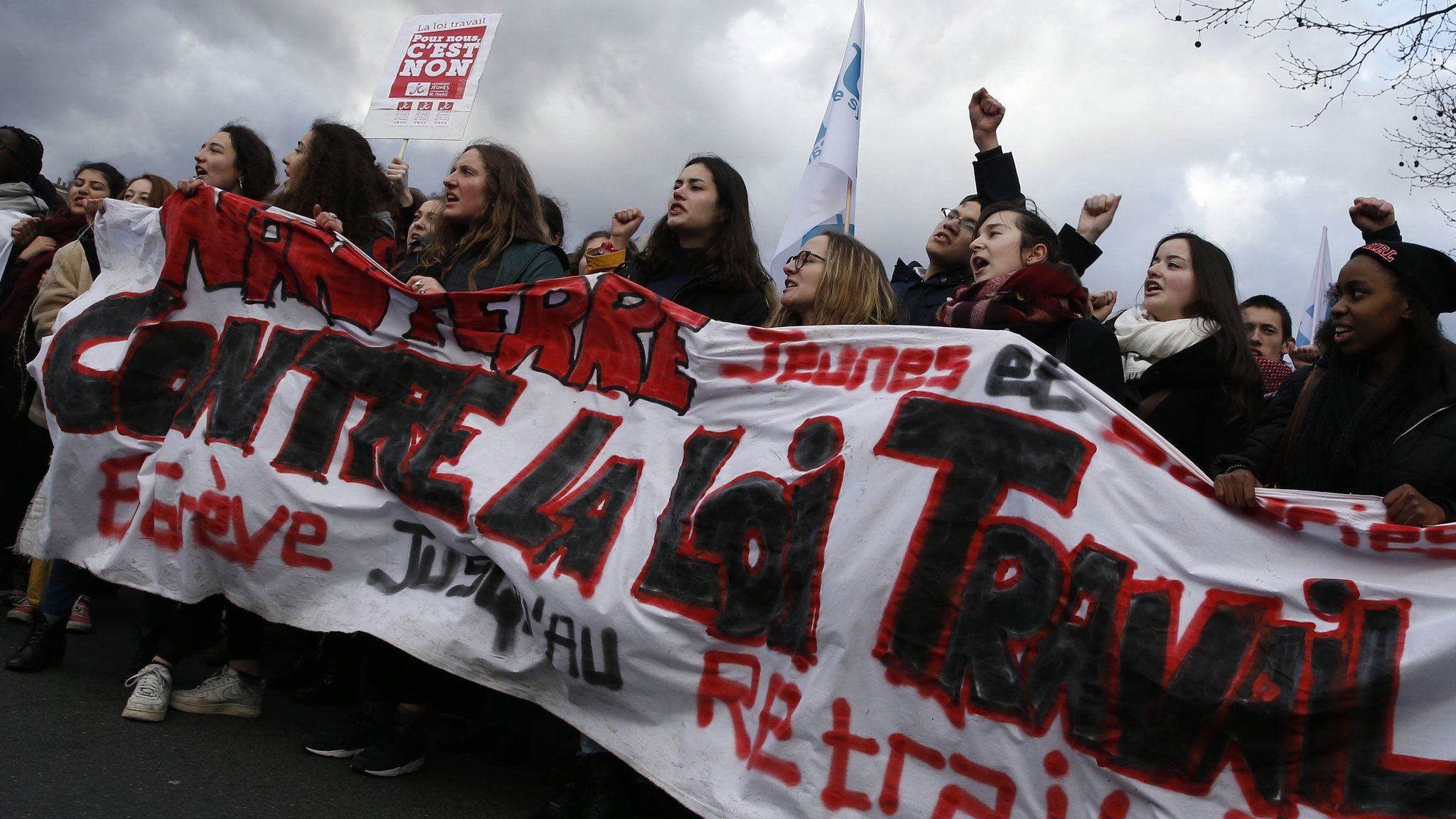 Protesters hold a banner reading "Against the labour law, strike until withdrawal" as they take part in a demonstration on 9 March 2016, in Paris, during a nationwide day of protest against proposed labour reforms