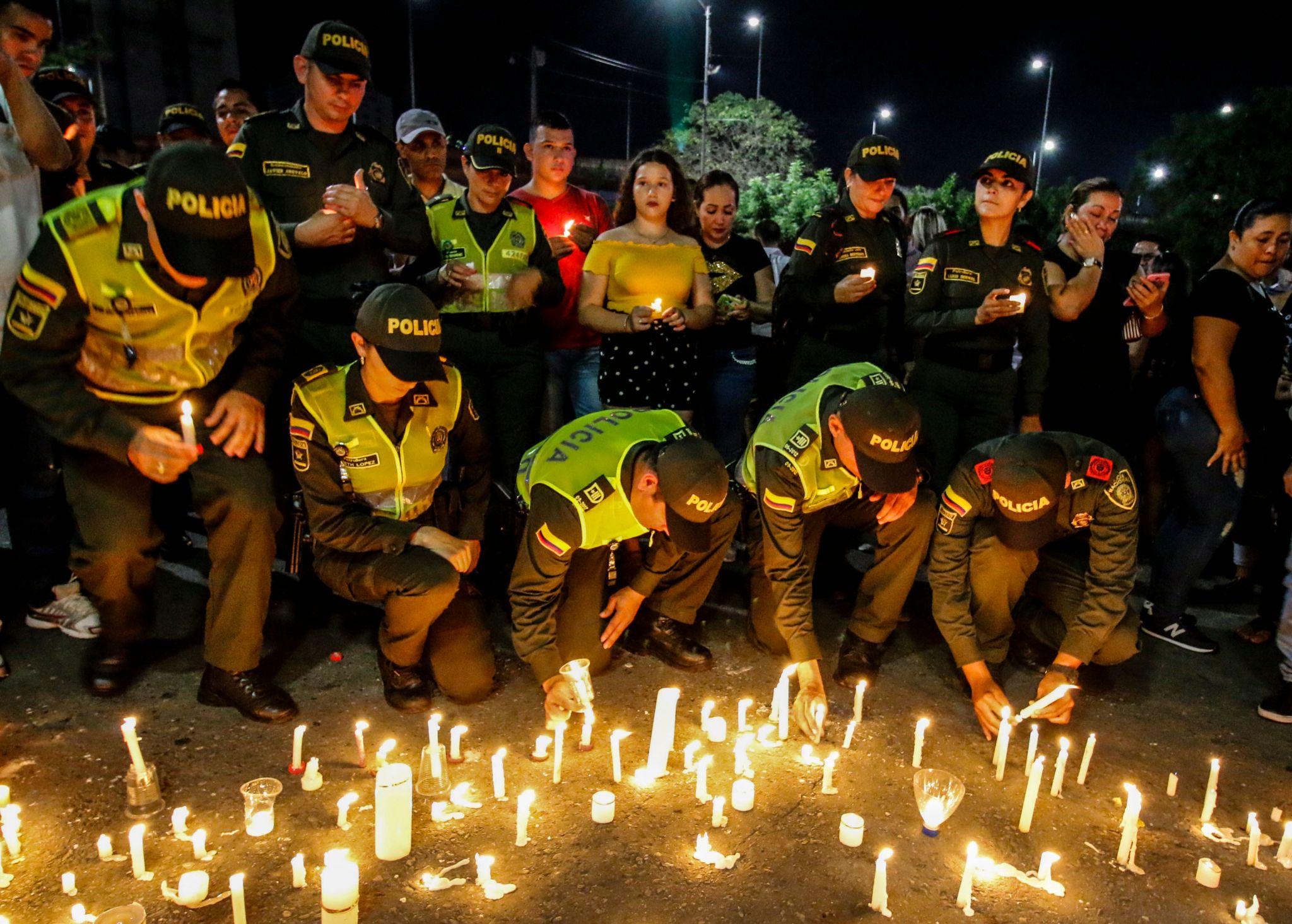 Police officers light candles in memory of their colleagues killed in an attack on the police academy