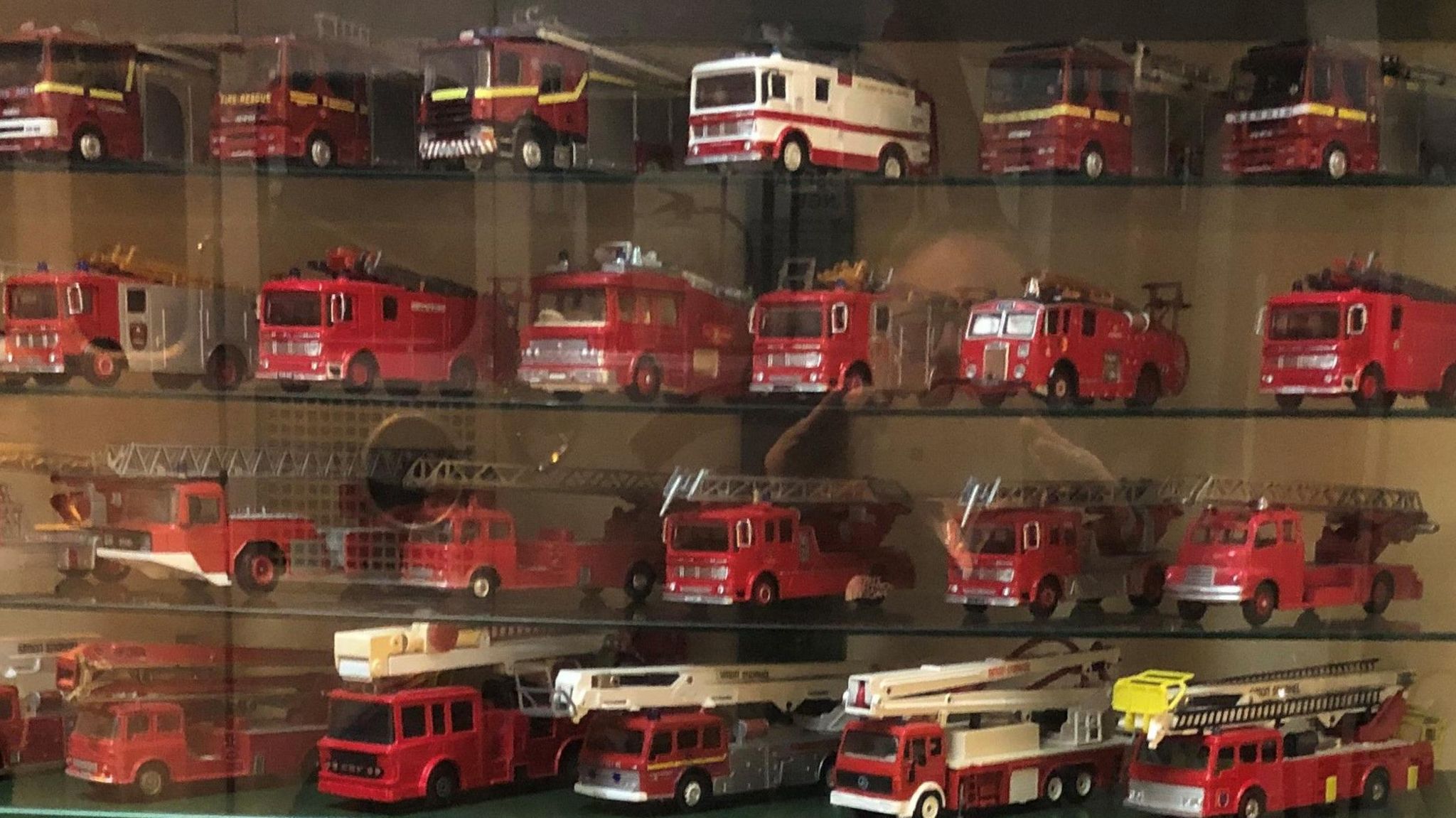 Toy fire engines in a glass cabinet