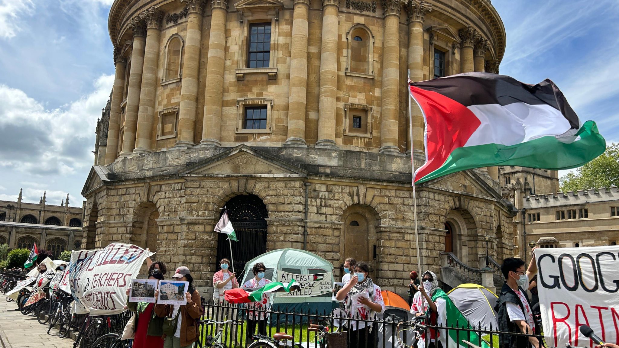 Protesters with palestinian flags outside the radcliffe camera