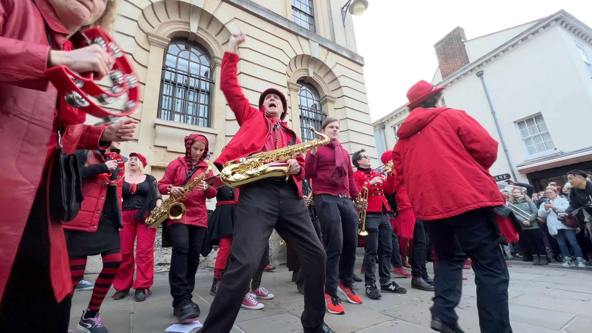 A band dressed in red playing saxophones.