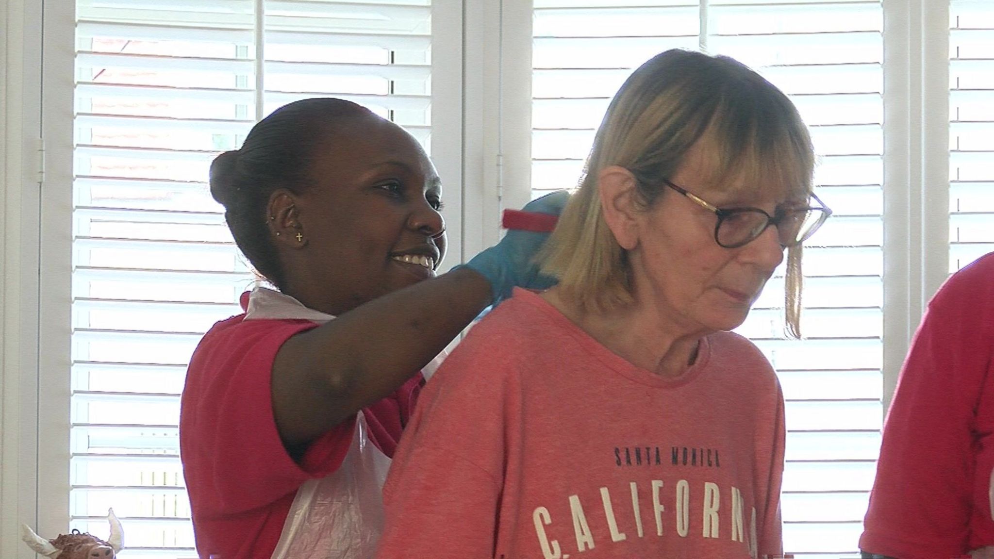 Carole having her hair combed by one of her carers