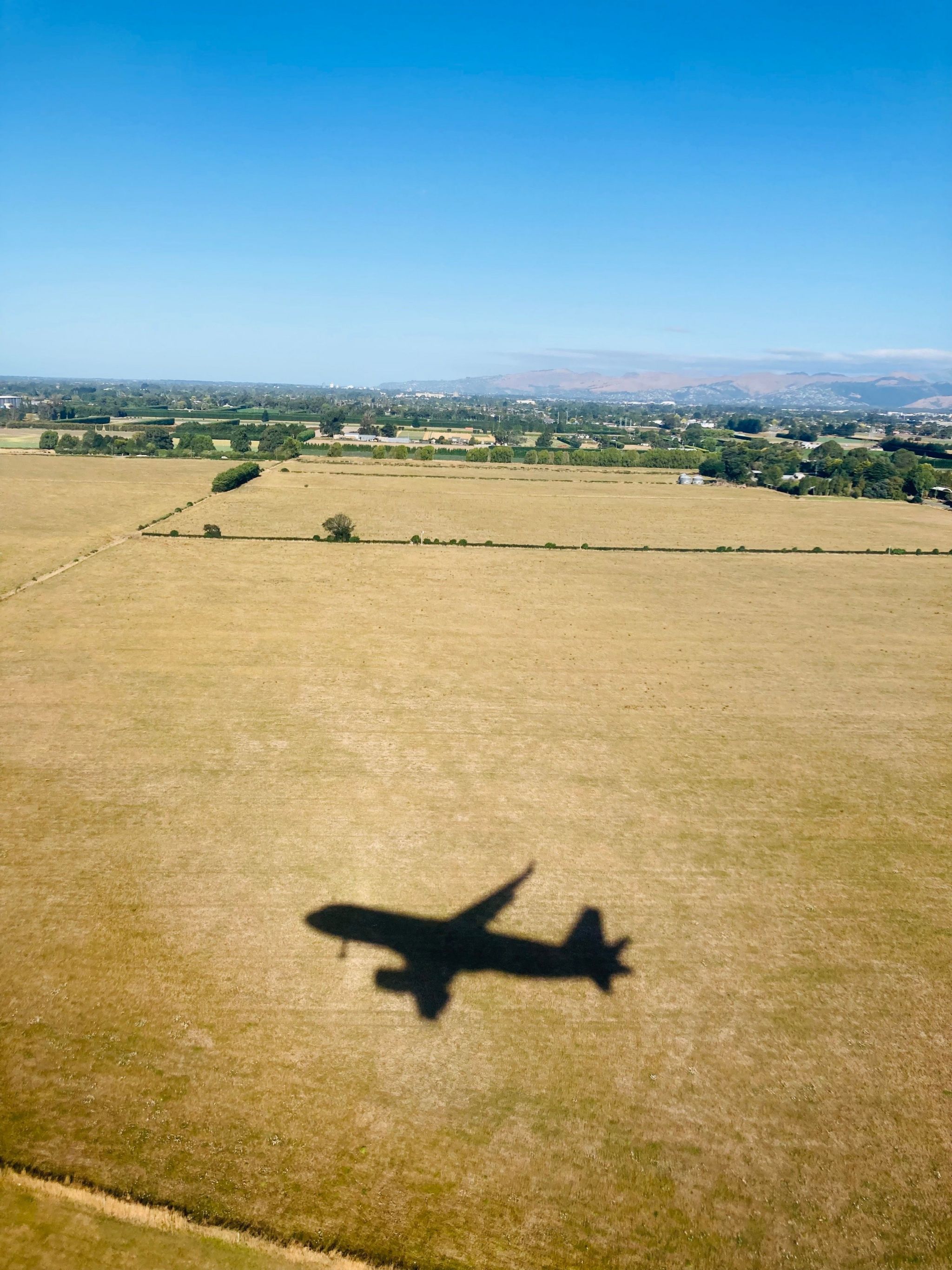 The shadow of an aeroplane as it flies over a field
