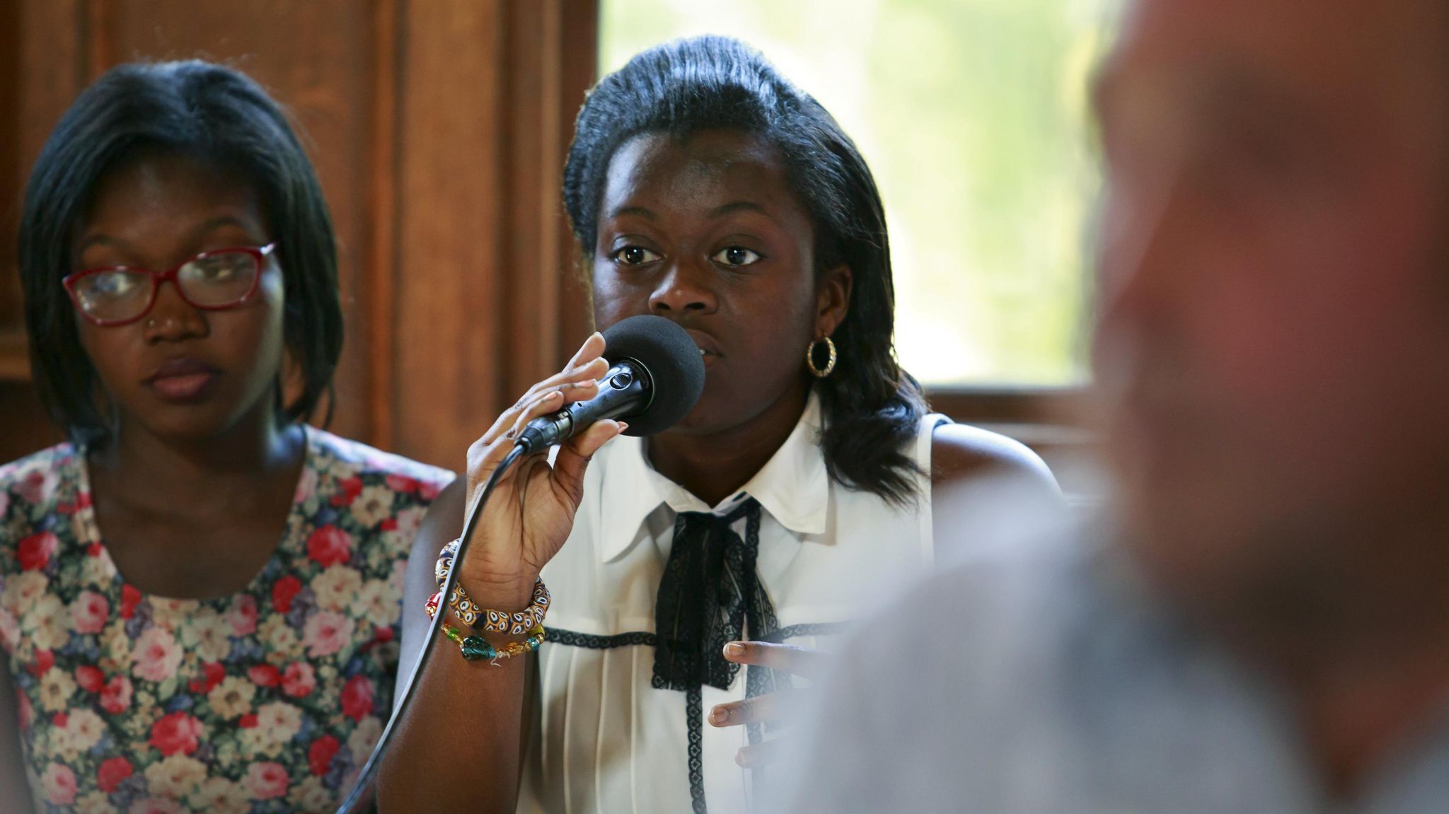 Linda Gyamfi holding a microphone and speaking at an event