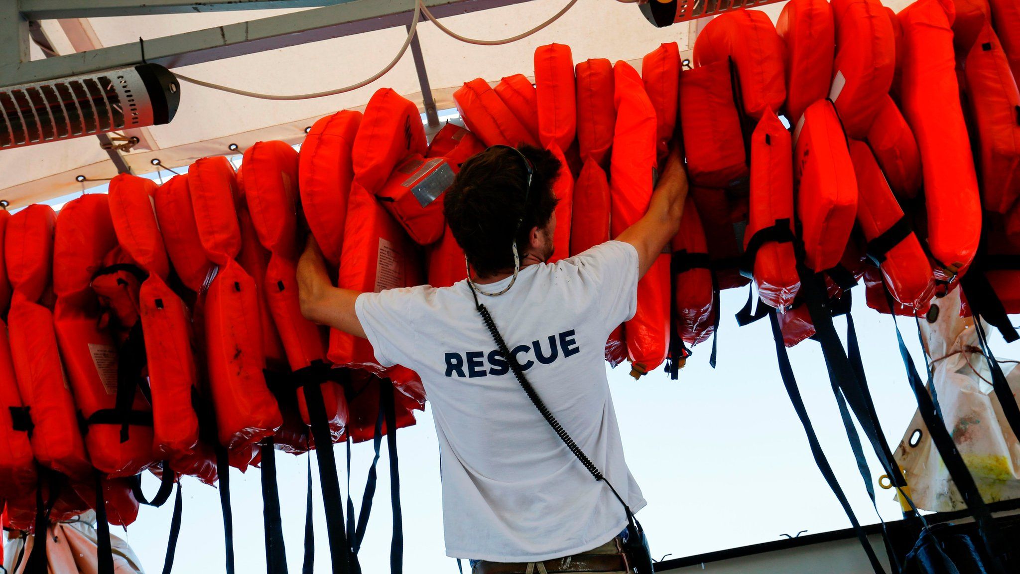 A member of SOS-Mediterranee checks life vests aboard the Aquarius rescue vessel, chartered by French NGO SOS-Mediterranee and Doctors Without Borders (MSF) as it sails to the SAR (Search and Rescue) area on June 22, 2018 in open sea between Algeria and Tunisia