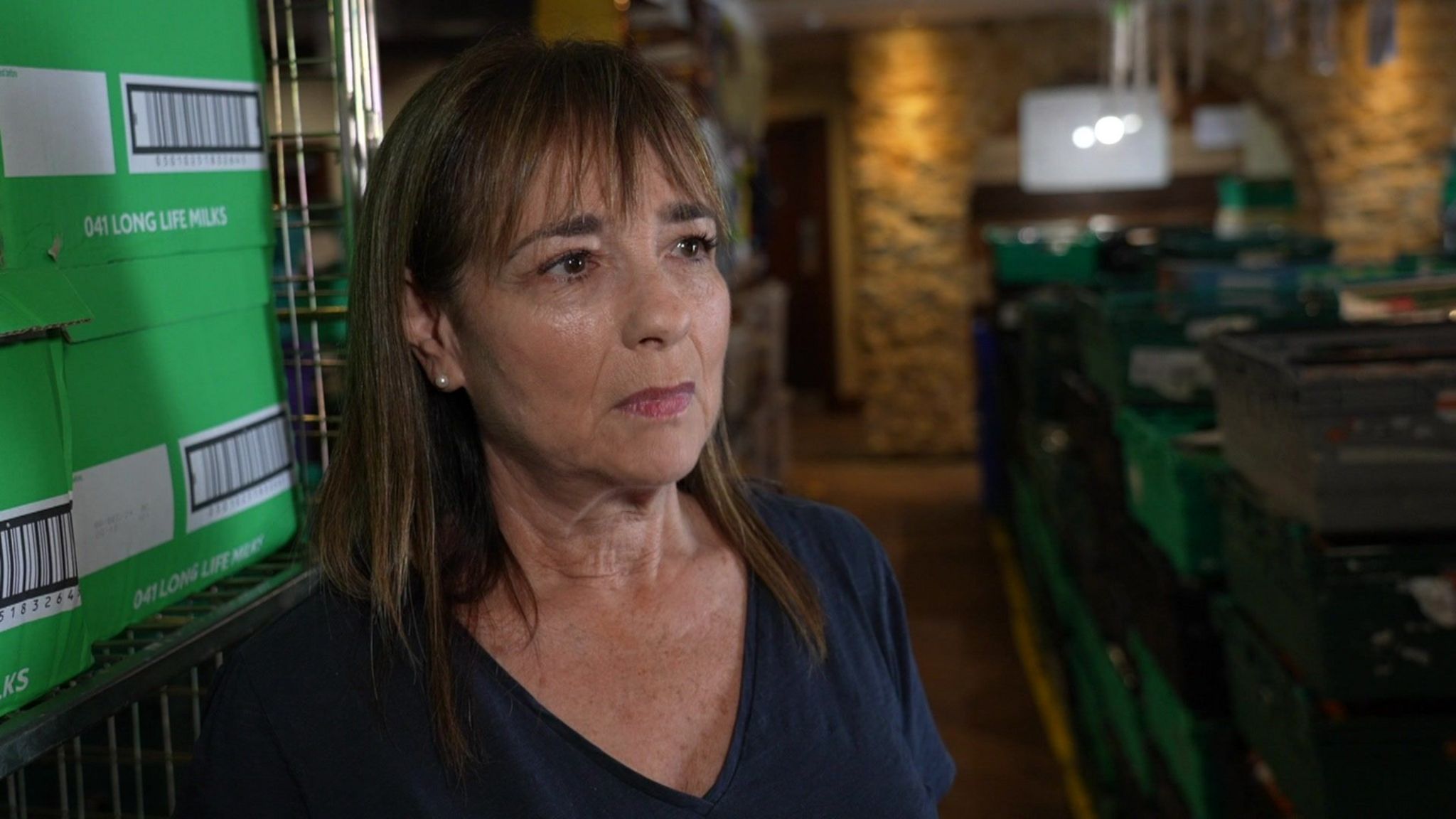 Naomi Russell inside a lit room with green crates behind her