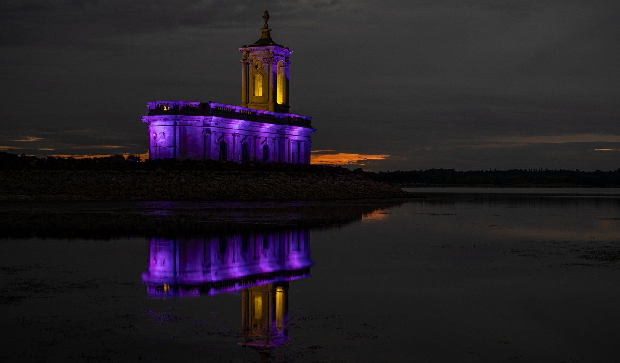Normanton Church at Rutland Water lit up in purple in tribute to the Queen