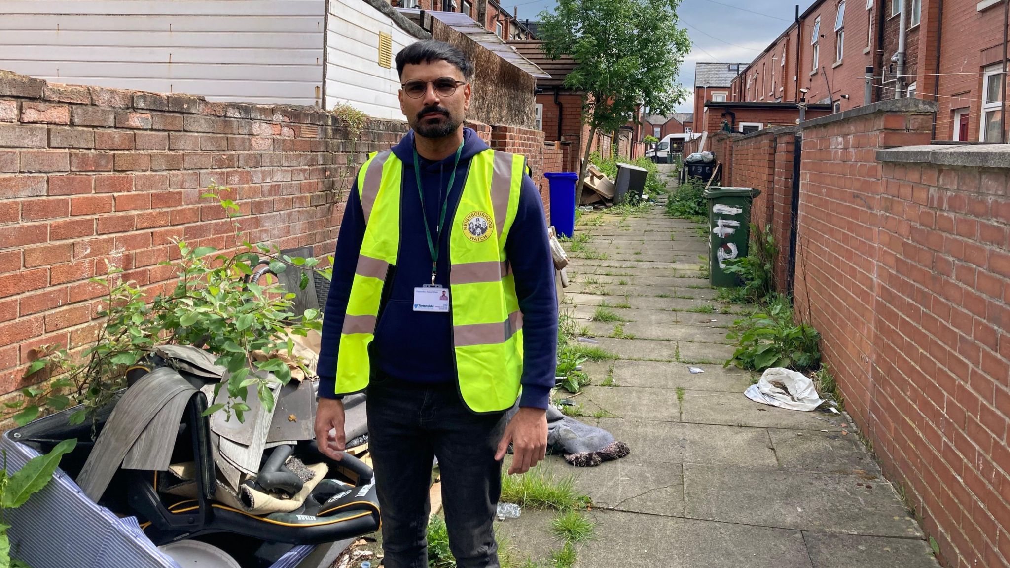 Councillor Kaleel Khan in an alleyway littered with rubbish