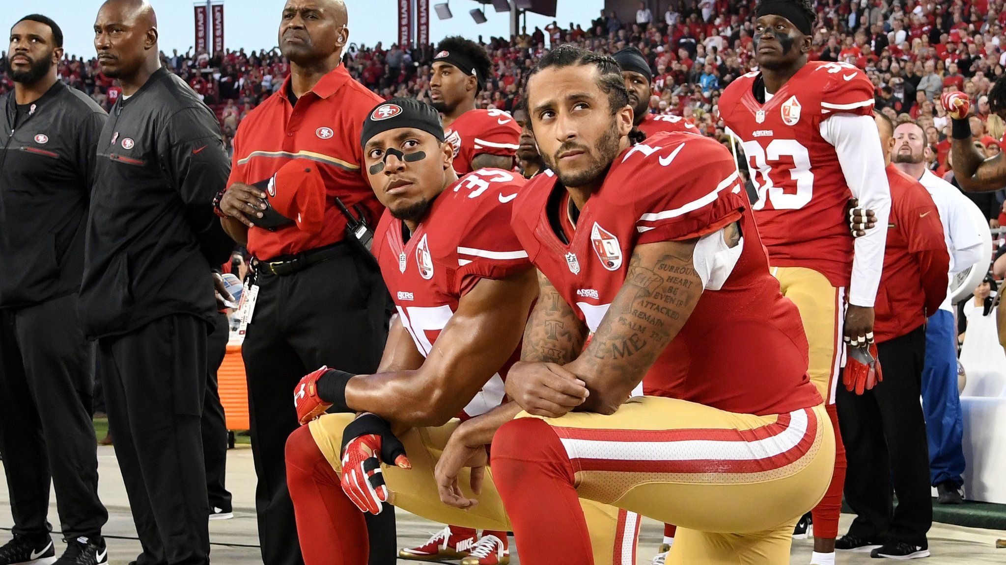 San Francisco 49ers players Eric Reid (left) and Colin Kaepernick (right) kneel during the US national anthem before an NFL game