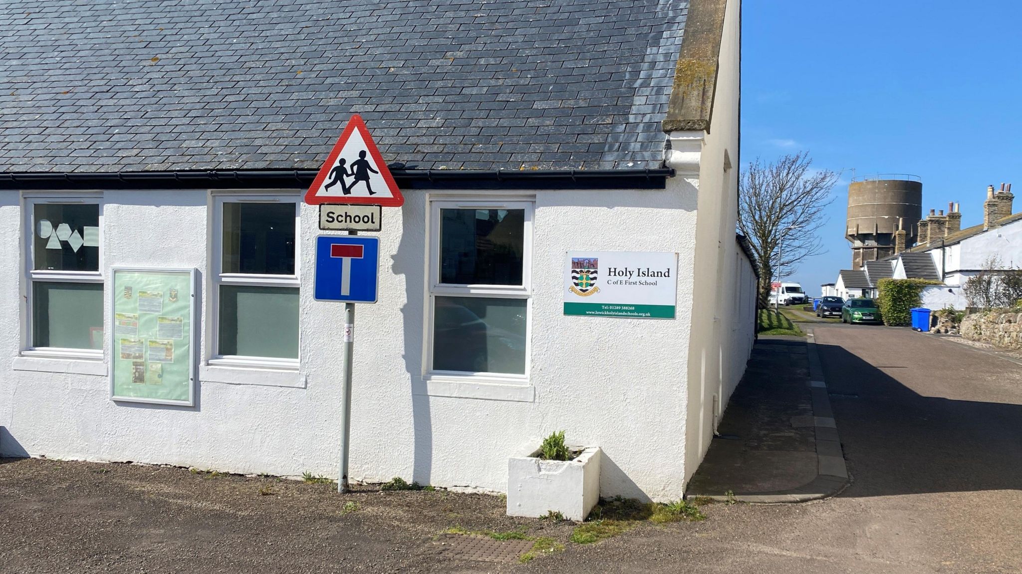 A small white building with a sign on it saying Holy Island 