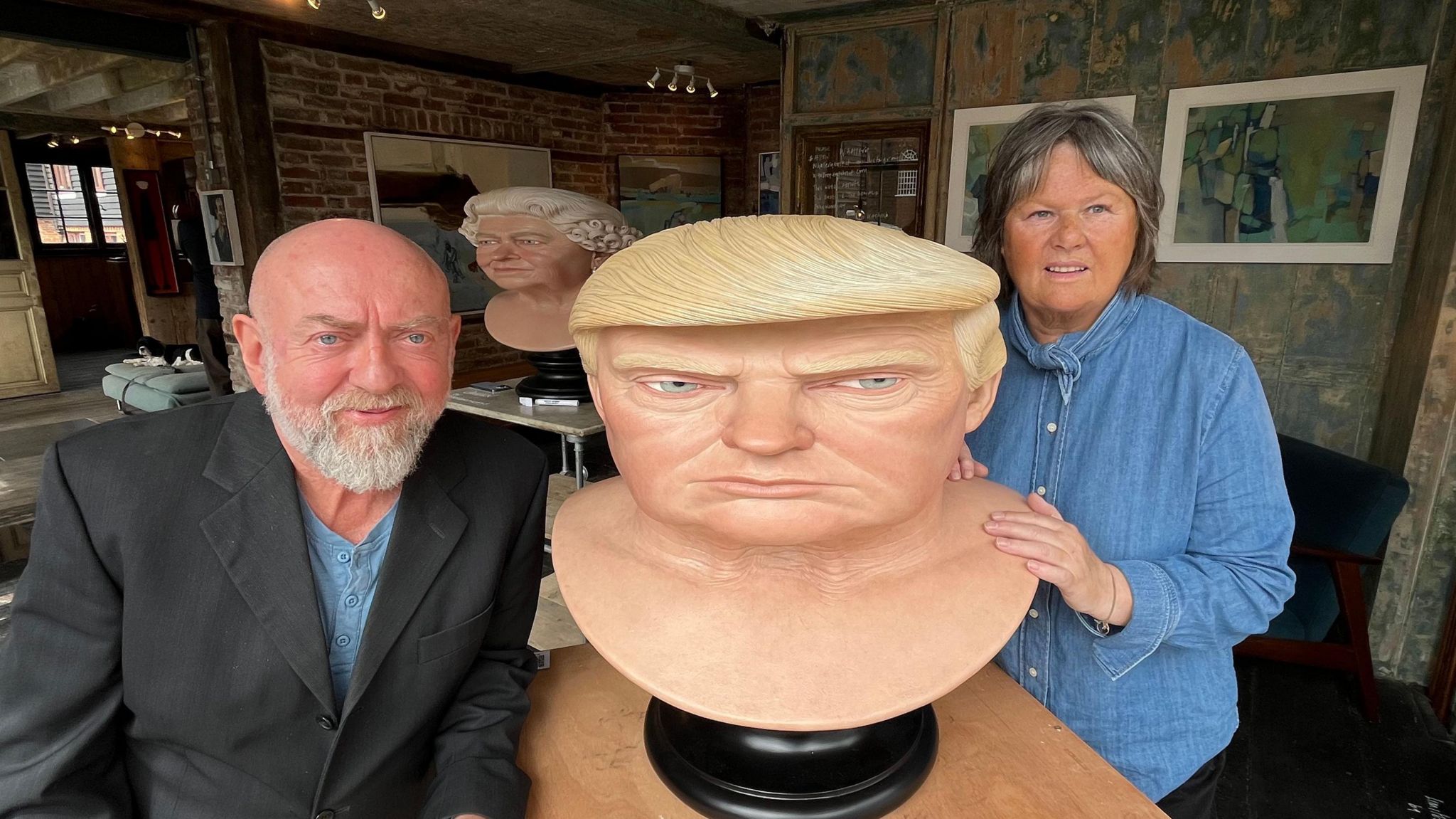 Artist John Humphreys and gallery owner Wendy Bowker stand on each side of the sculpture