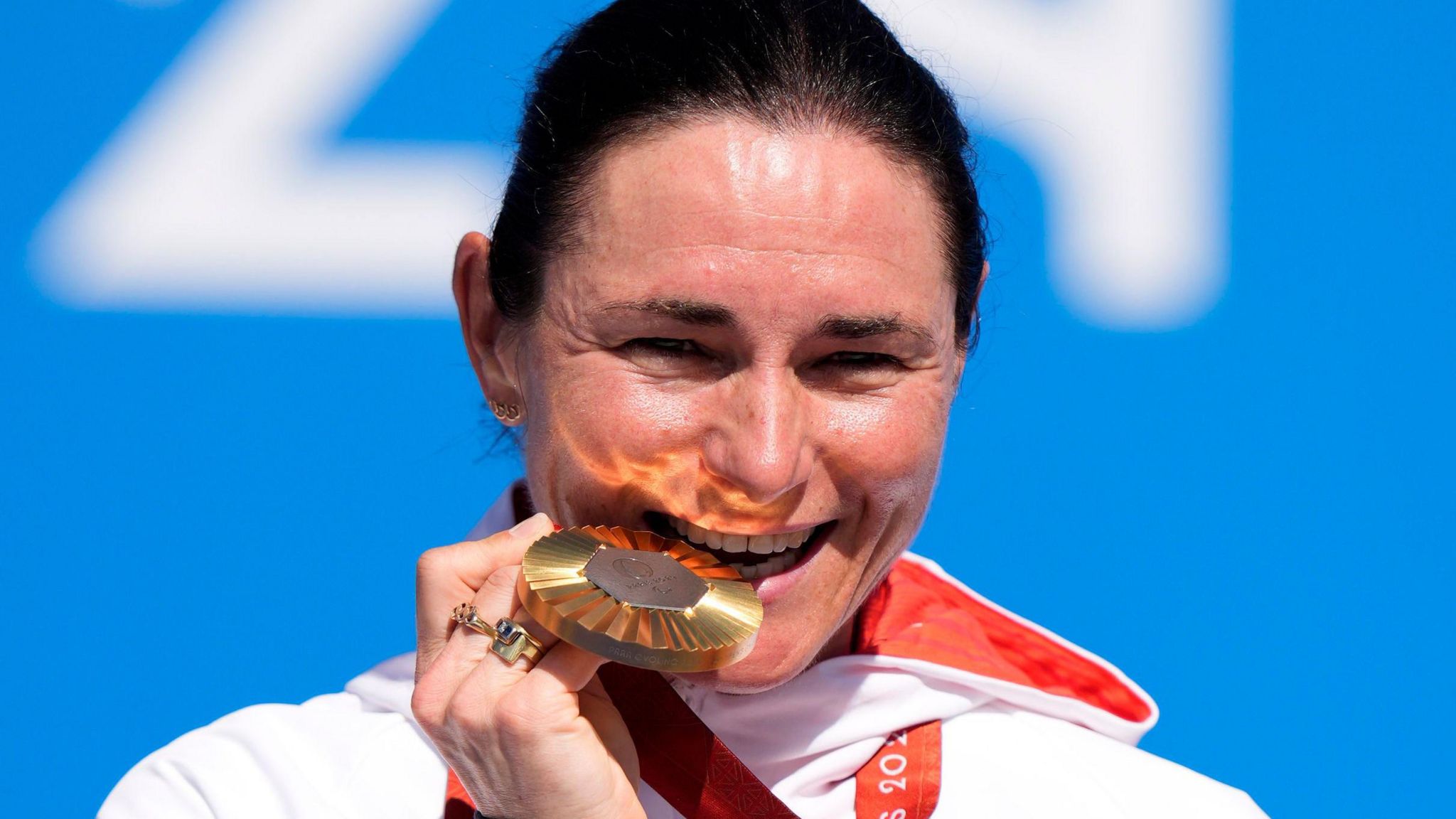 Sarah Storey bites her golden medal