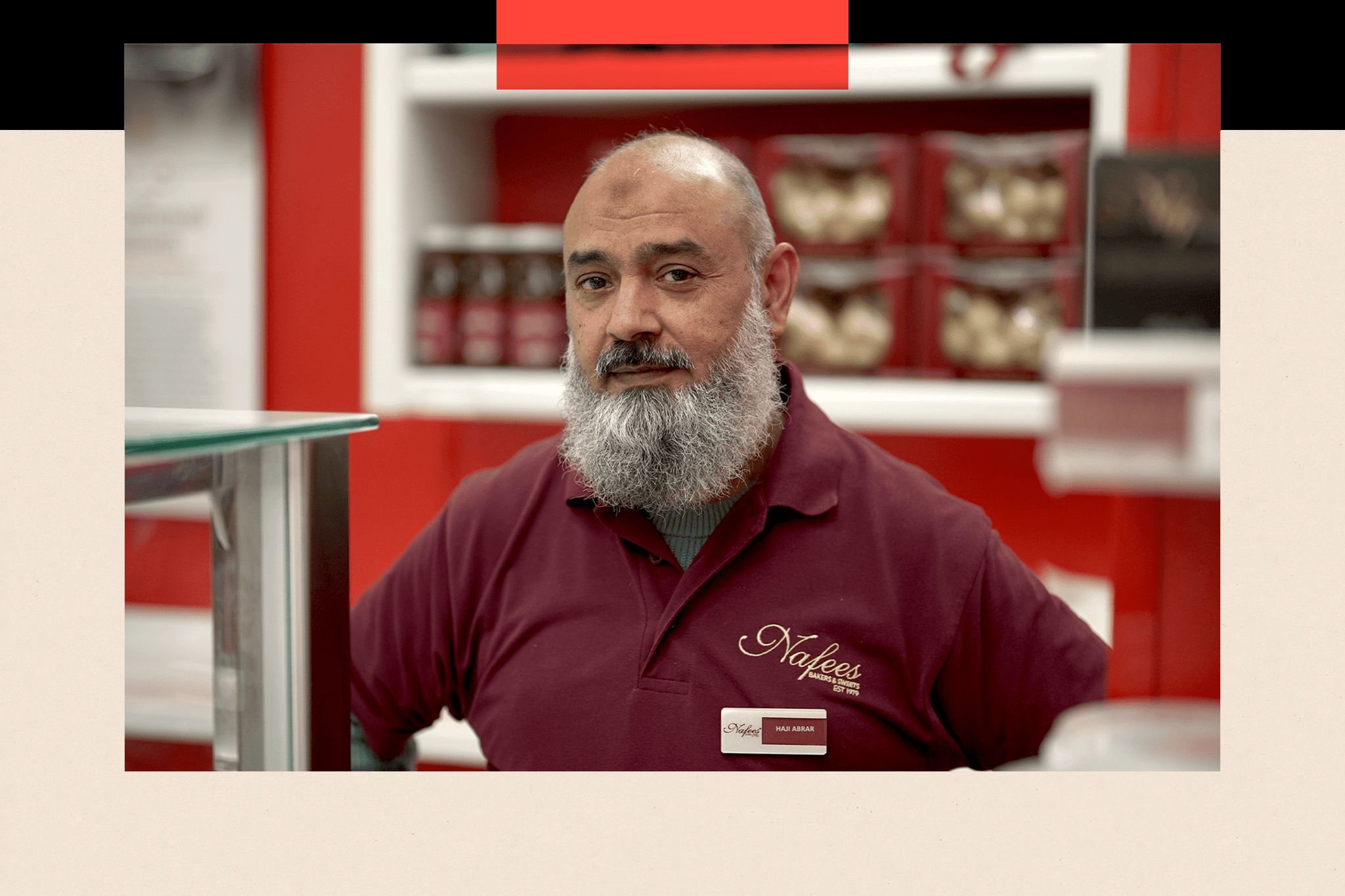 Haji, a man with a beard and a t-shirt, stands in a shop