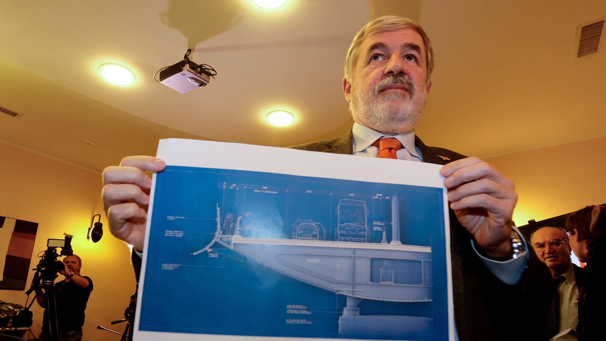 Mayor of Genoa Marco Bucci displays a section plan of the new bridge.