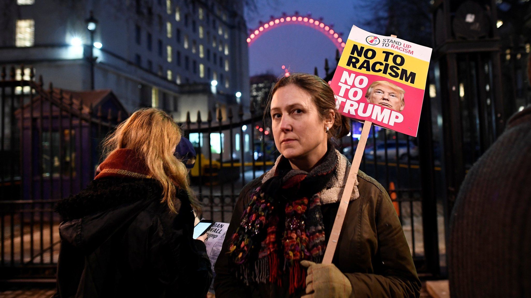 A woman holds a placard reading "no to racism, no to Trump" in central London during a protest against Donald Trump (January 30, 2017)