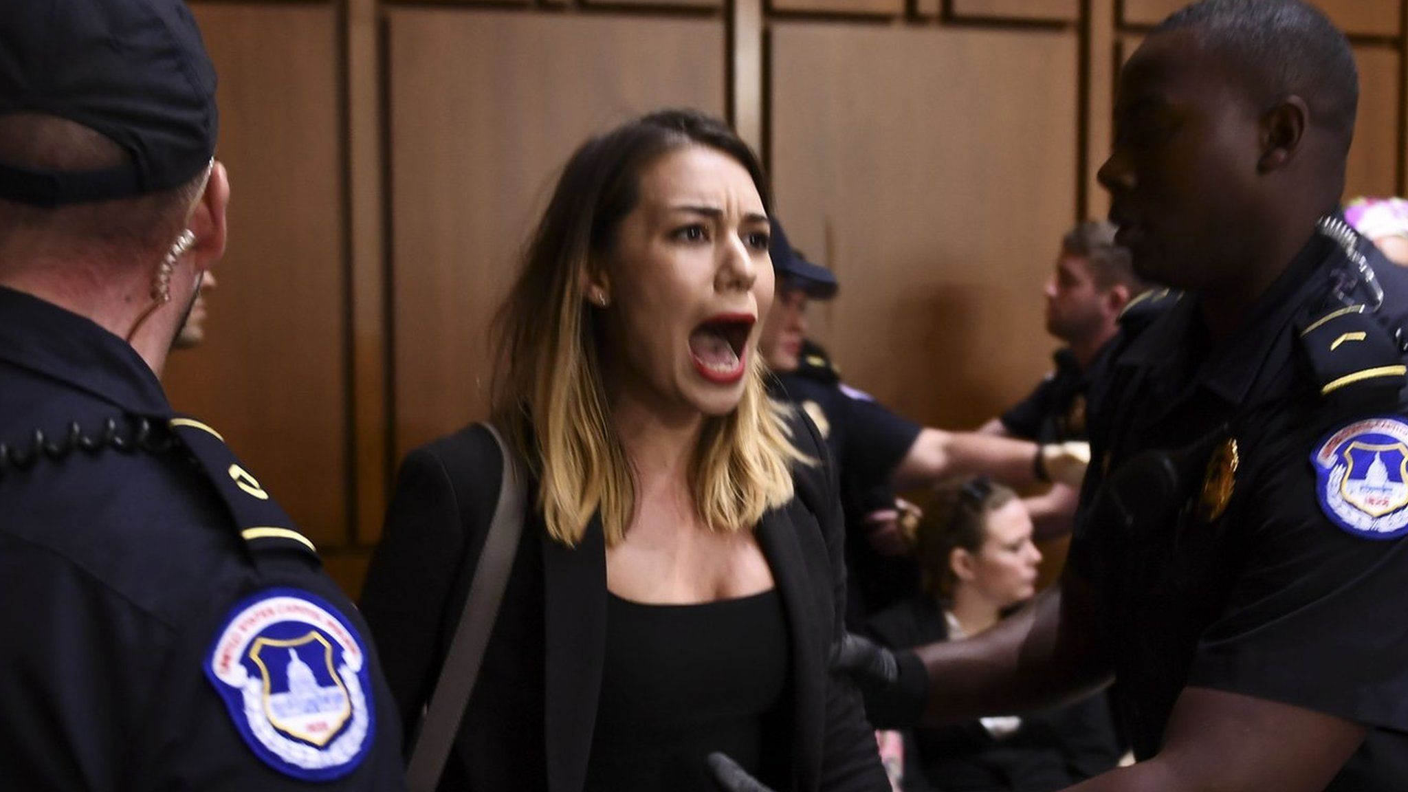 A woman protests as US Supreme Court nominee Brett Kavanaugh arrives on the first day of his confirmation hearing