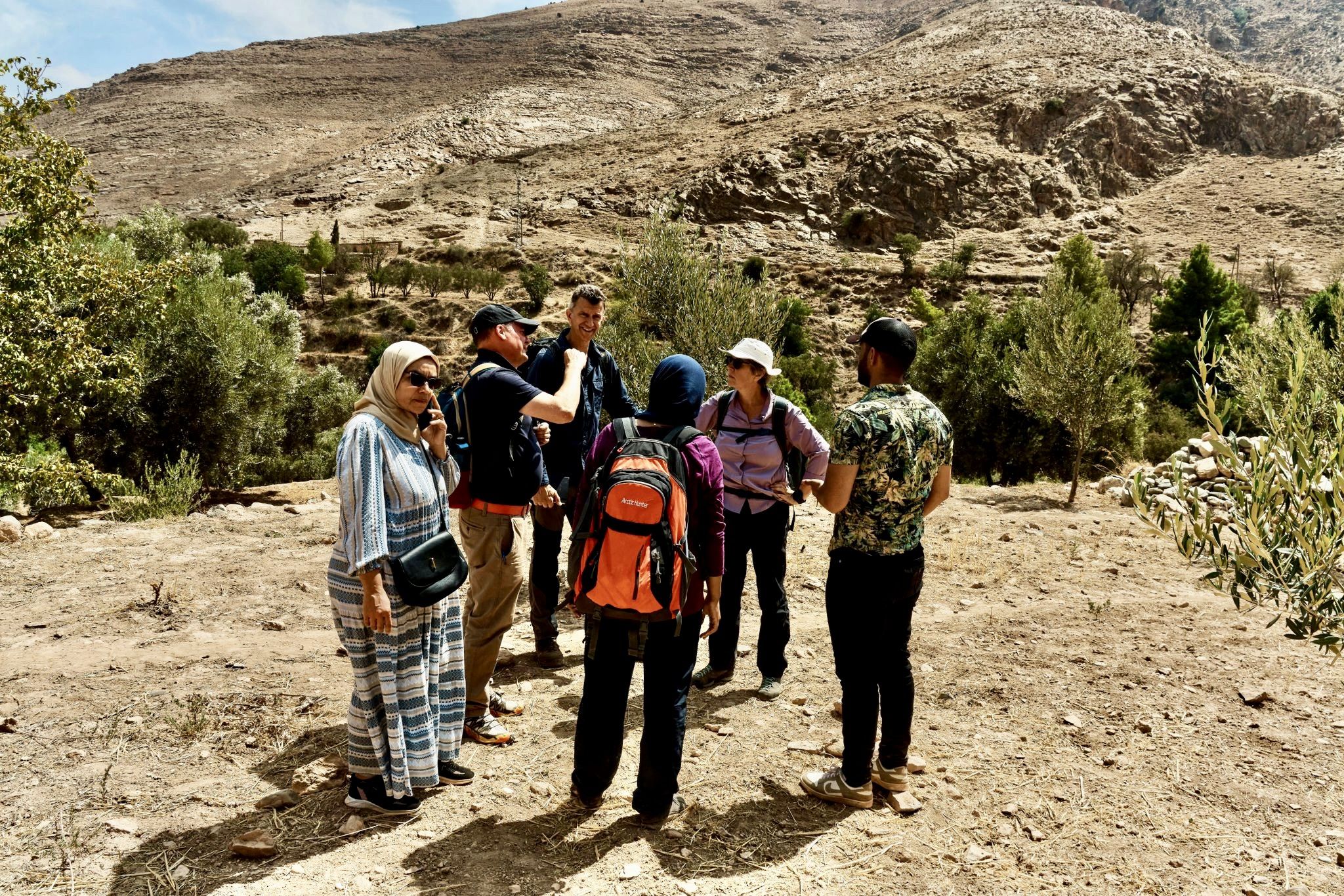 Six people standing on dry earth on the mountain