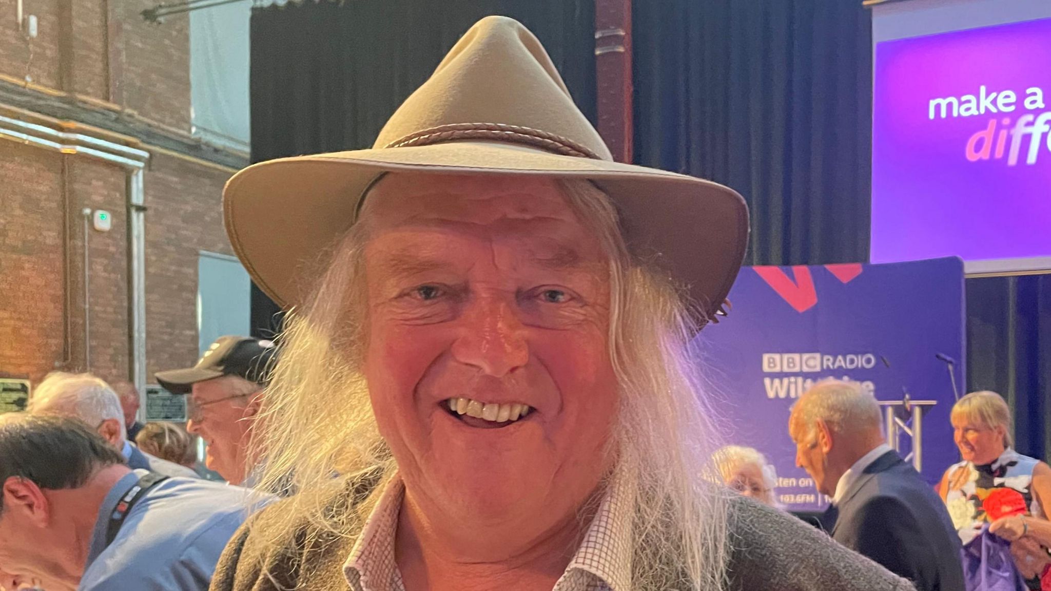 Phil Harding looks into the camera smiling and wearing a hat