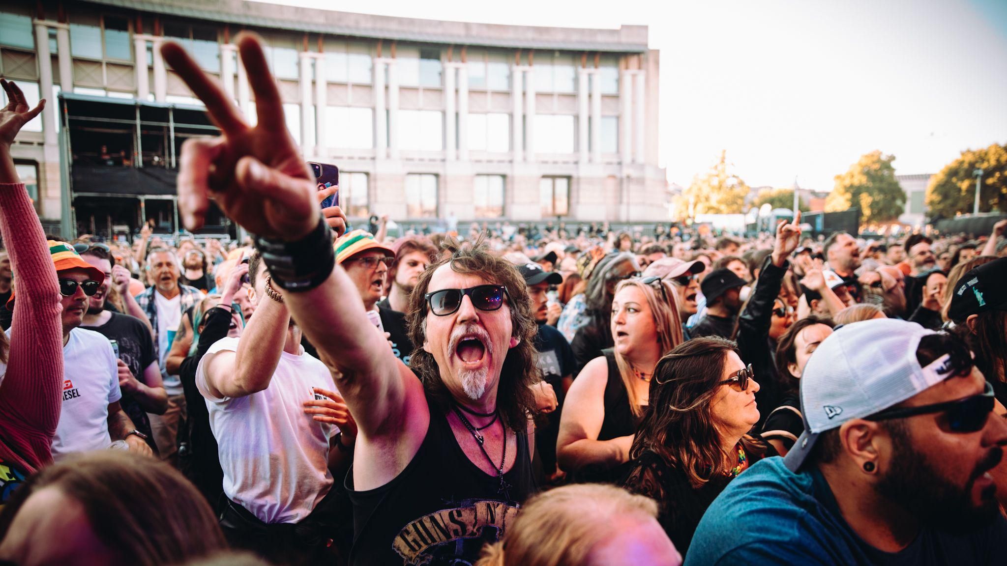 A man with long hair raises an arm as the crowd watched Skindred at Bristol Sounds 2024