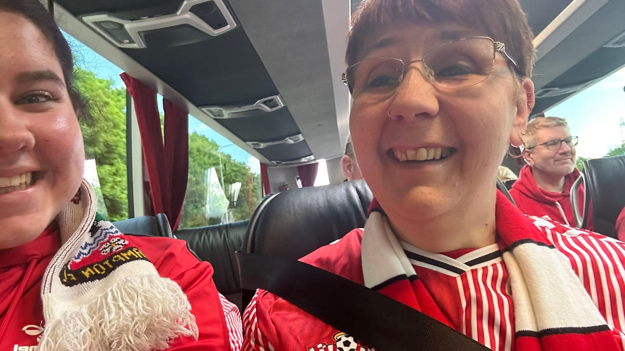 two women in red and white saints-branded clothes