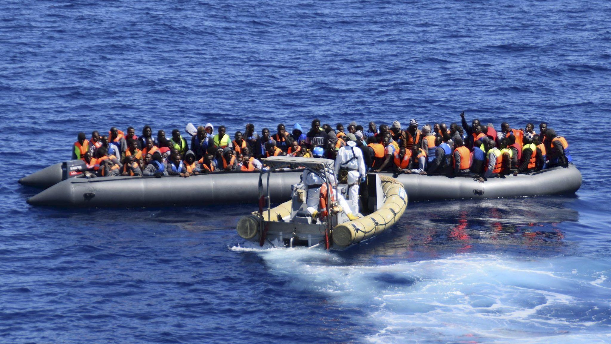 Migrants sit in their boat during a rescue operation by Italian Navy vessels off the coast of Sicily (11 April 2016) (Italian Navy handout)