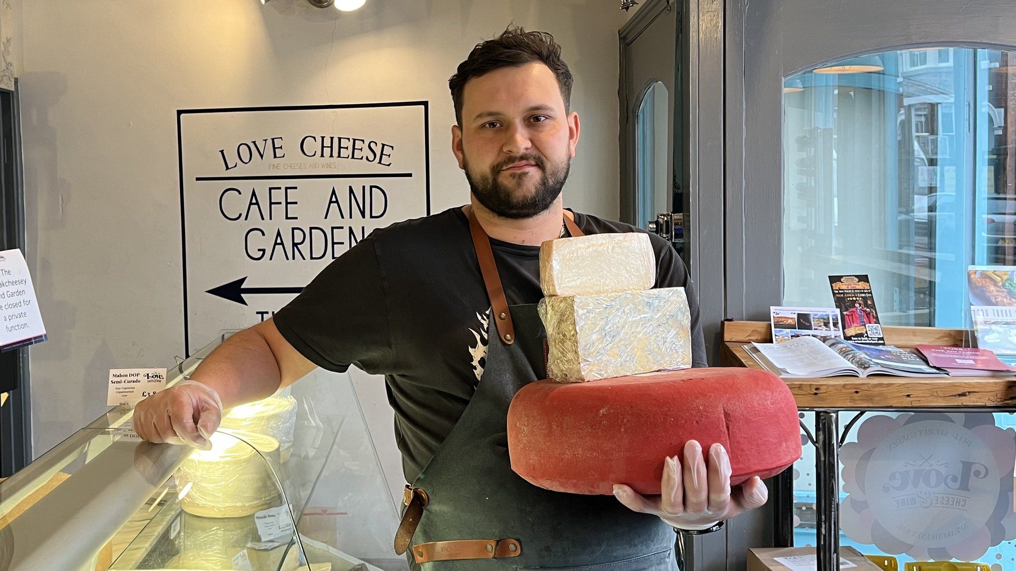 Man in shop holding cheese