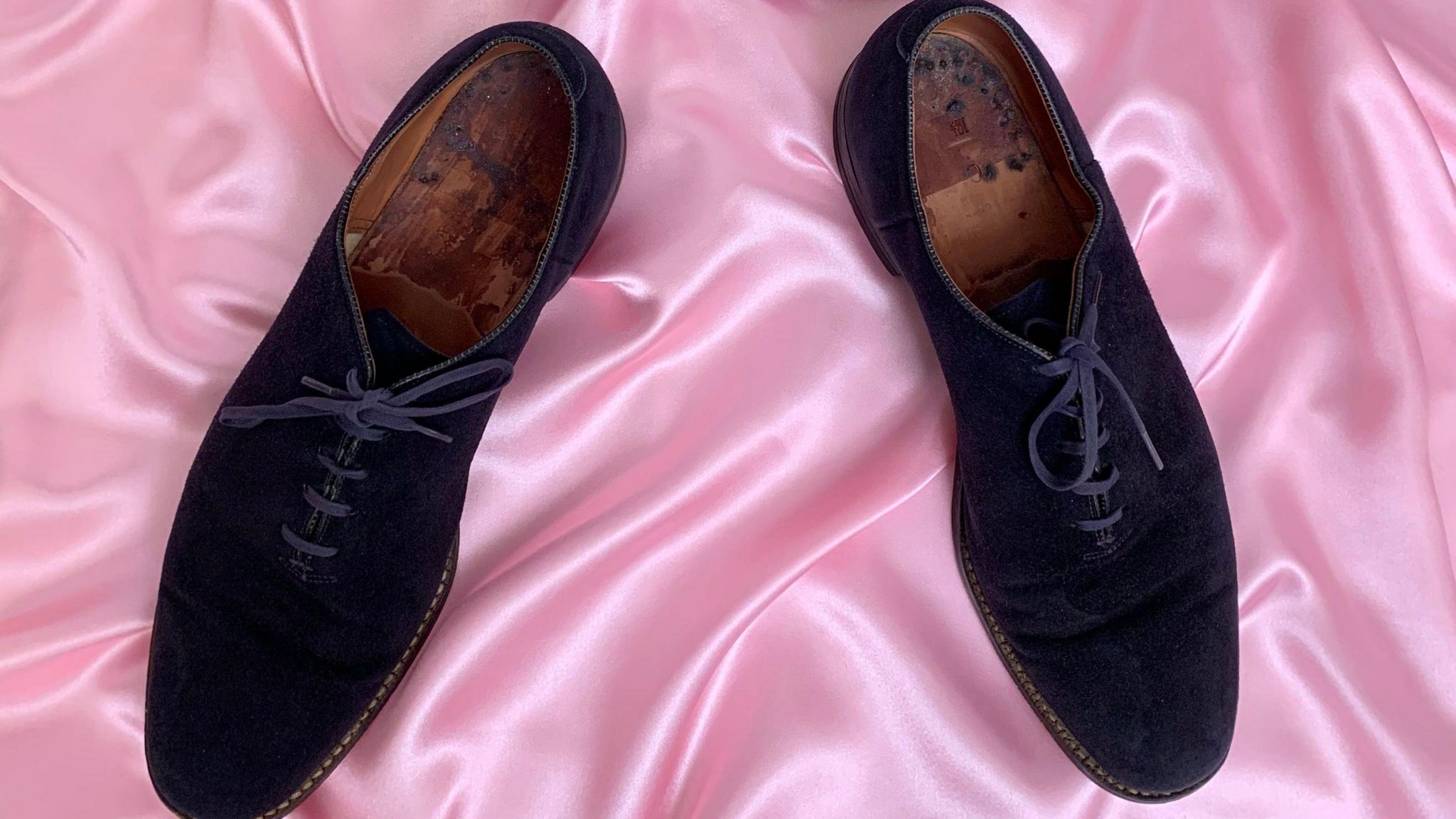 The blue suede shoes on a pink velvet sheet