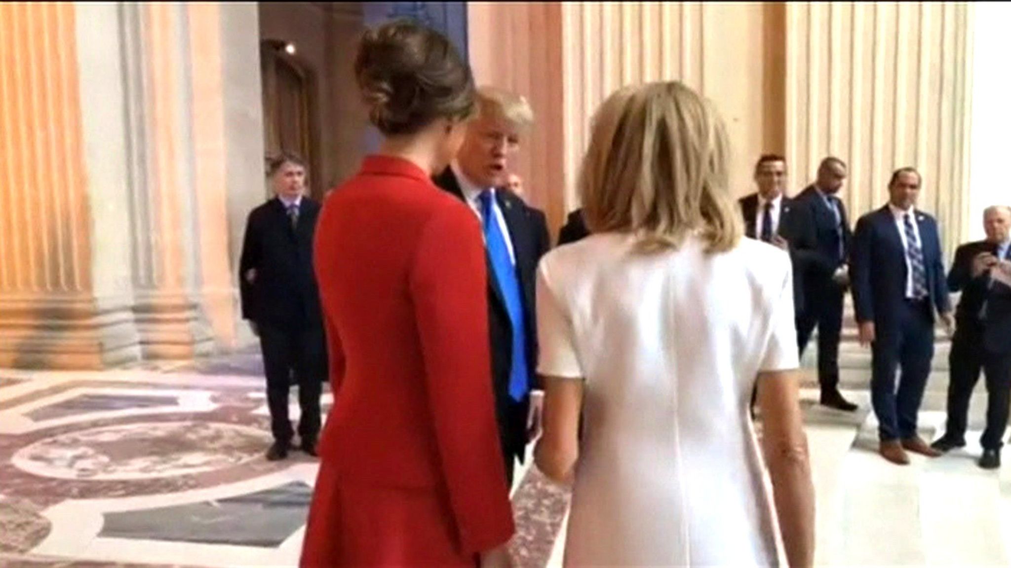 Donald Trump speaking to Brigitte Macron