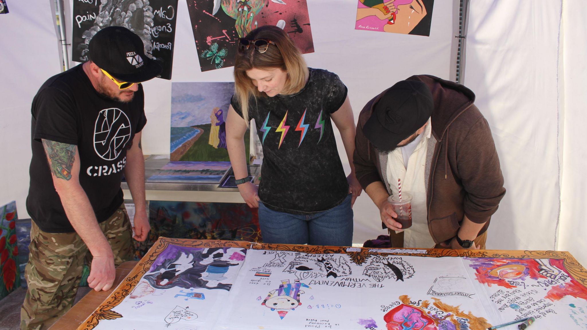 People looking at drawings on a table 