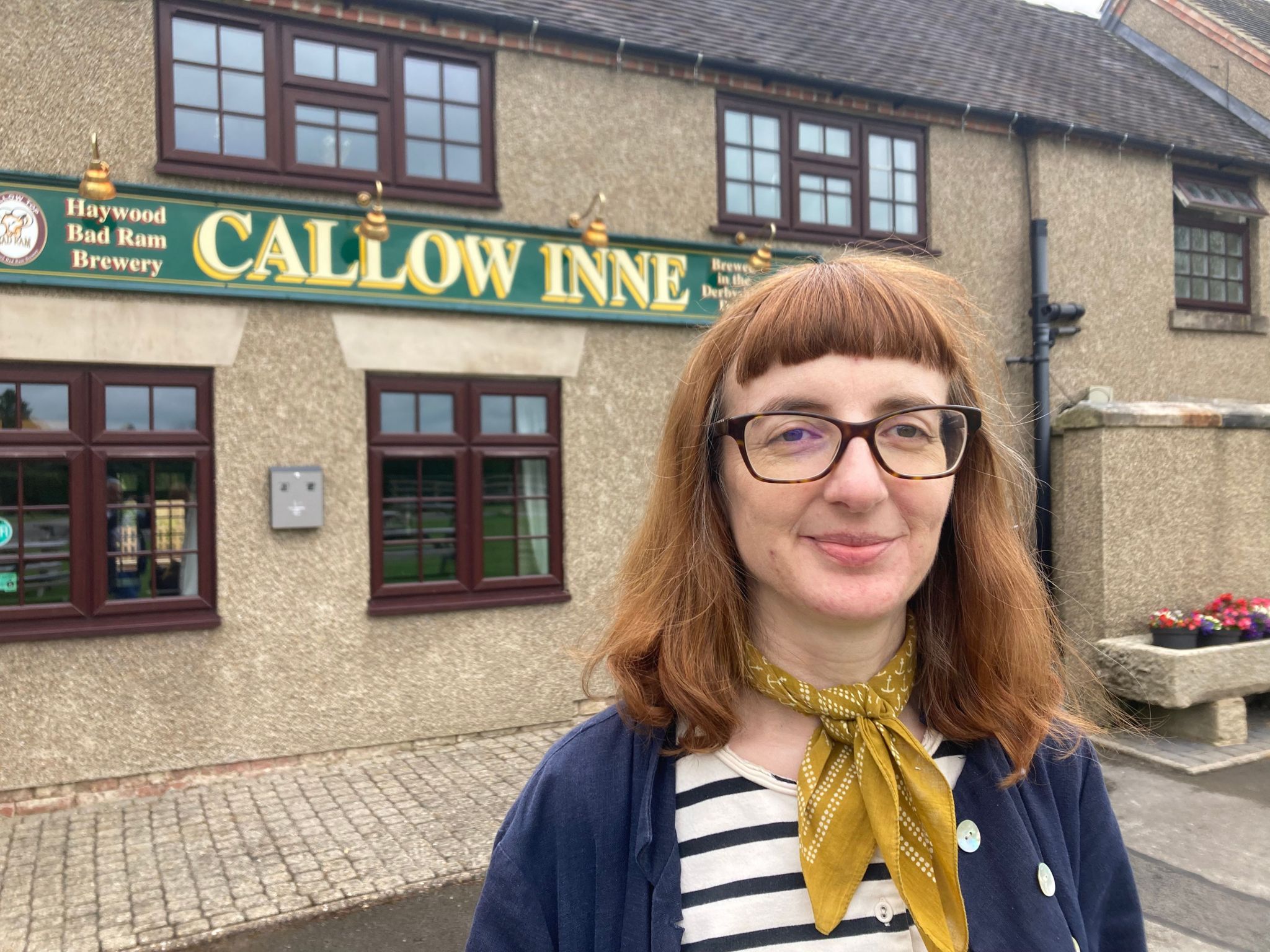 Brunette woman standing in front of a pub