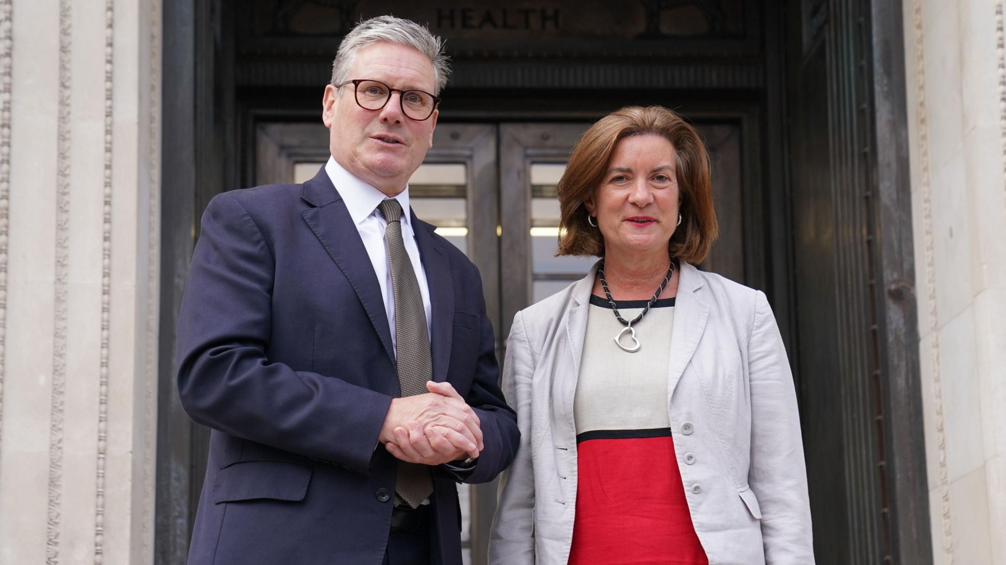 Sir Keir Starmer and Eluned Morgan standing next to each other on the steps of the Welsh government's Cathays Park building