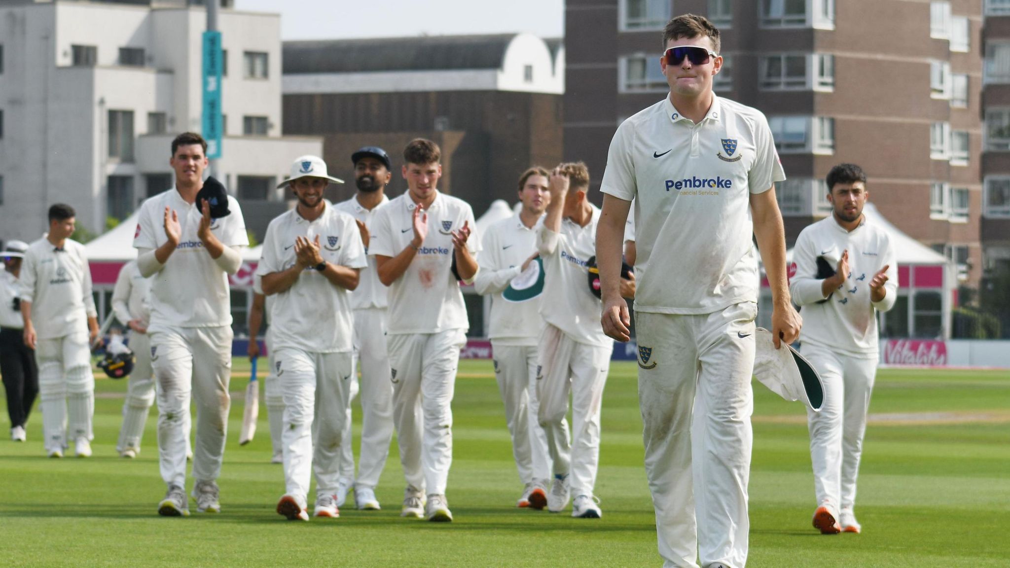 Sussex spinner Jack Carson is applauded off by his team-mates after his career best 11-157 against Derbyshire at Hove