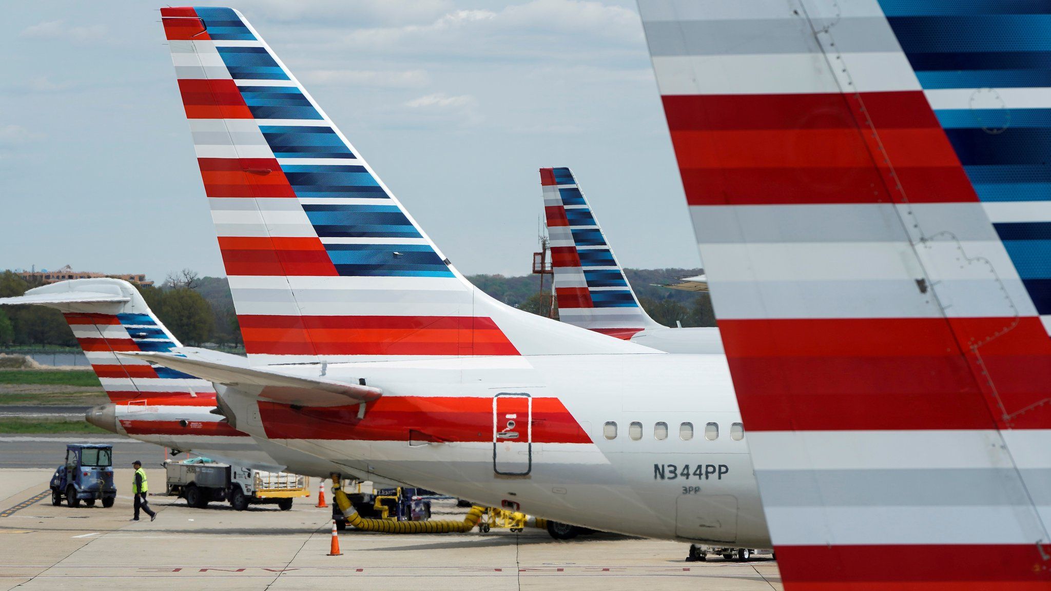 A member of a ground crew walks past American Airlines planes parked at the gate during the coronavirus disease (COVID-19) outbreak at Ronald Reagan National Airport in Washington, U.S., April 5, 2020.