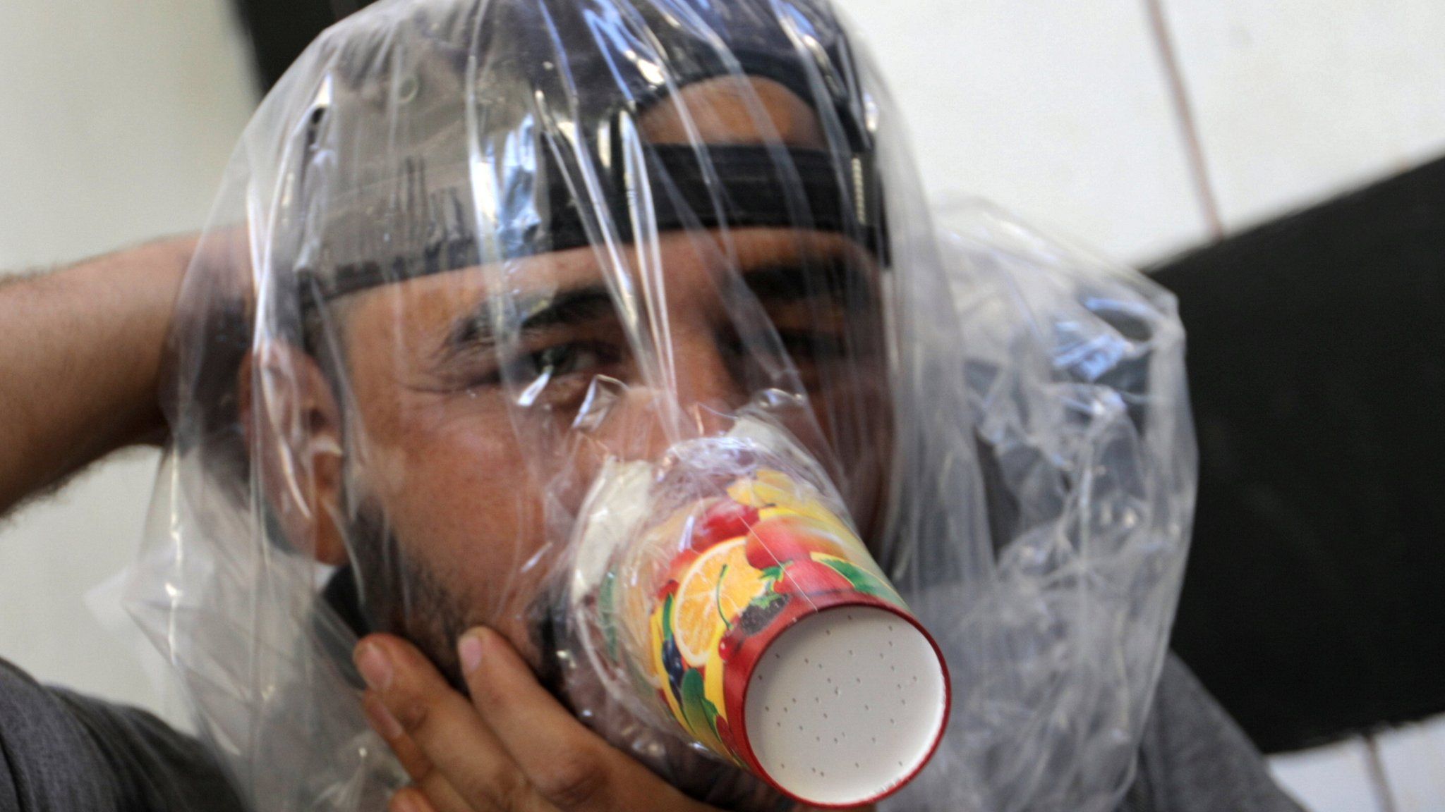 Hudhayfa al-Shahad tries an improvised gas mask in Idlib, Syria September 3, 2018