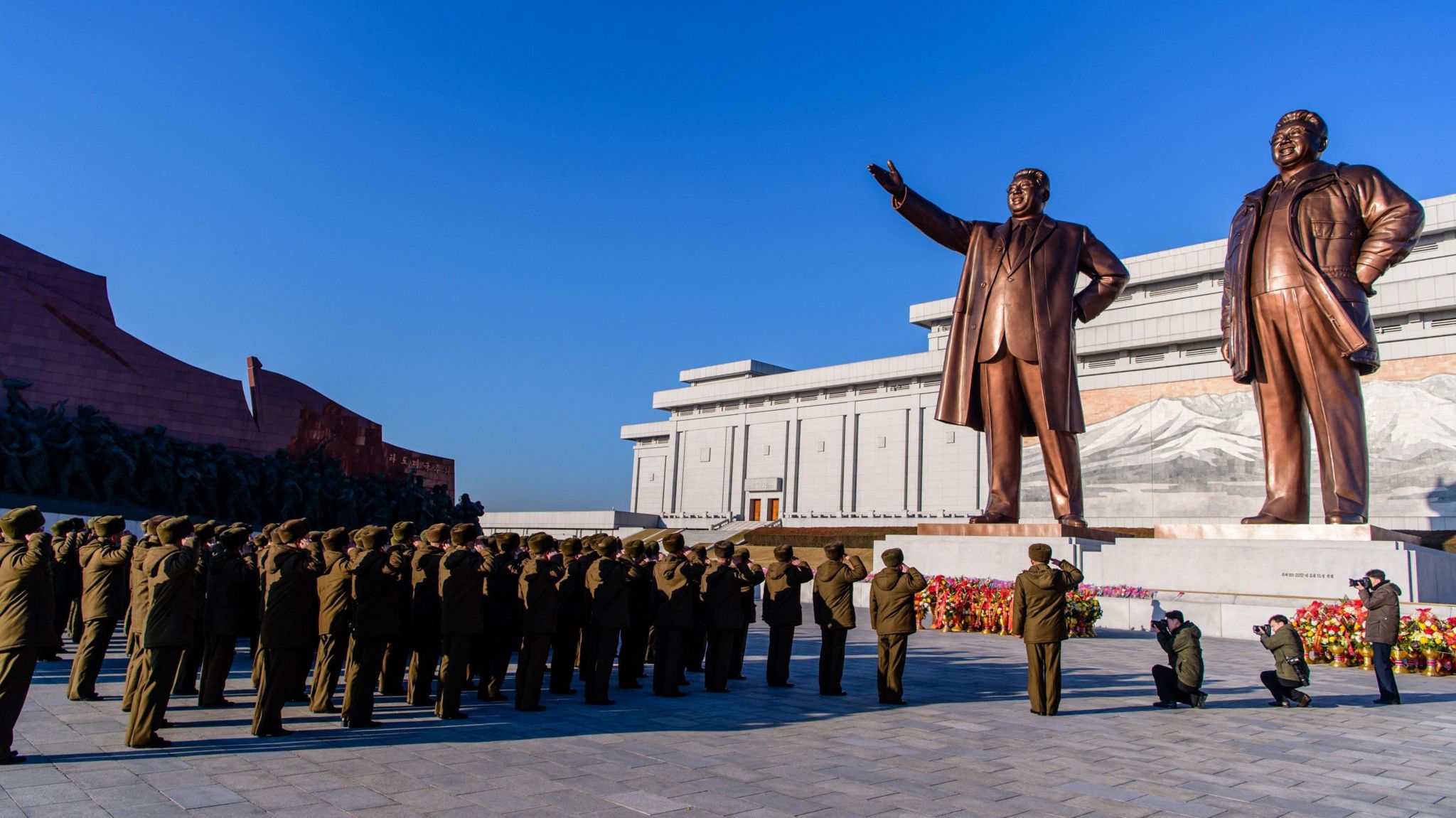 People pay tribute to the statues of Kim Il-sung and Kim Jong-il in Pyongyang