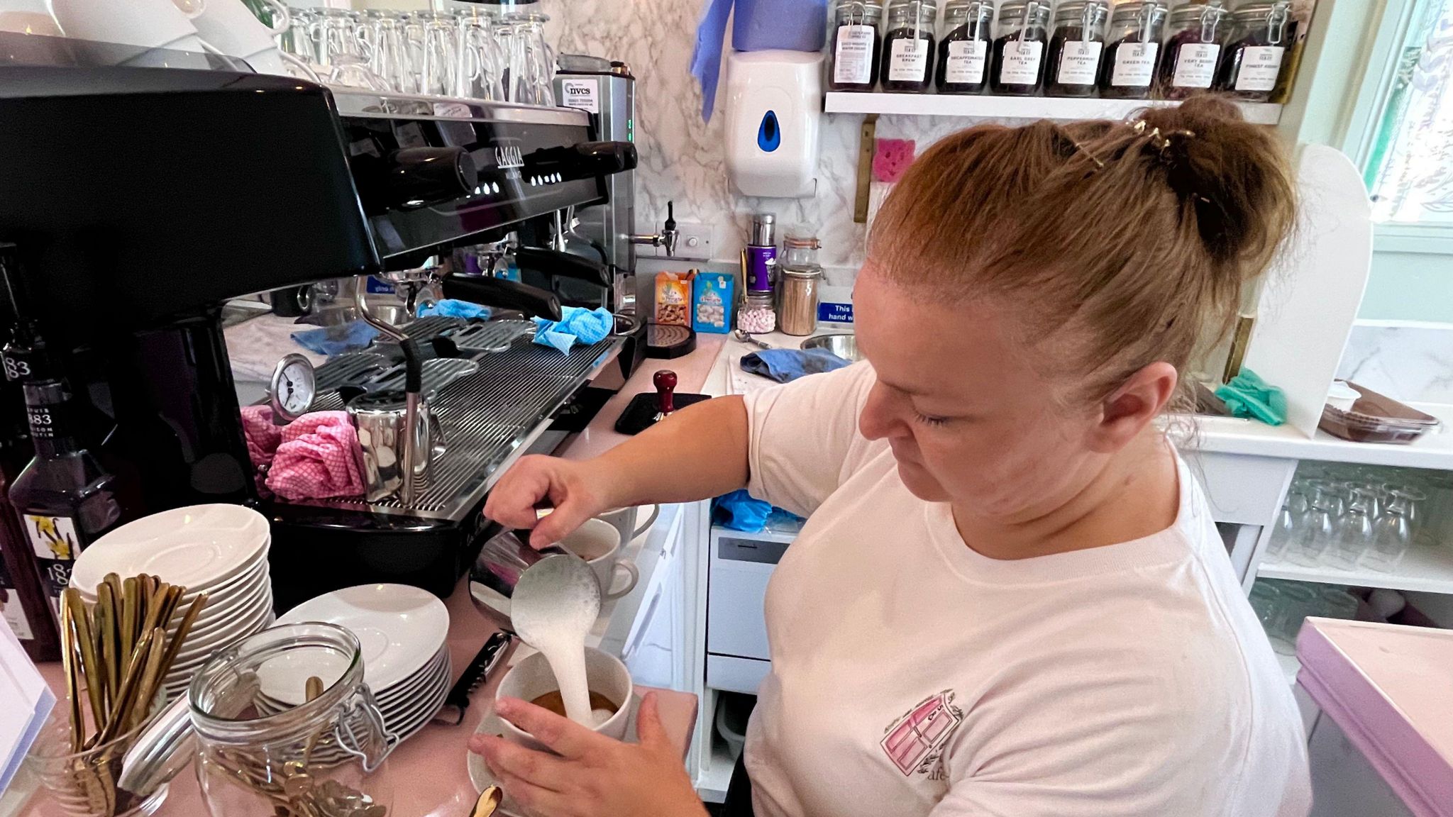 Tina Smart making coffee and pouring milk into a cup in cafe