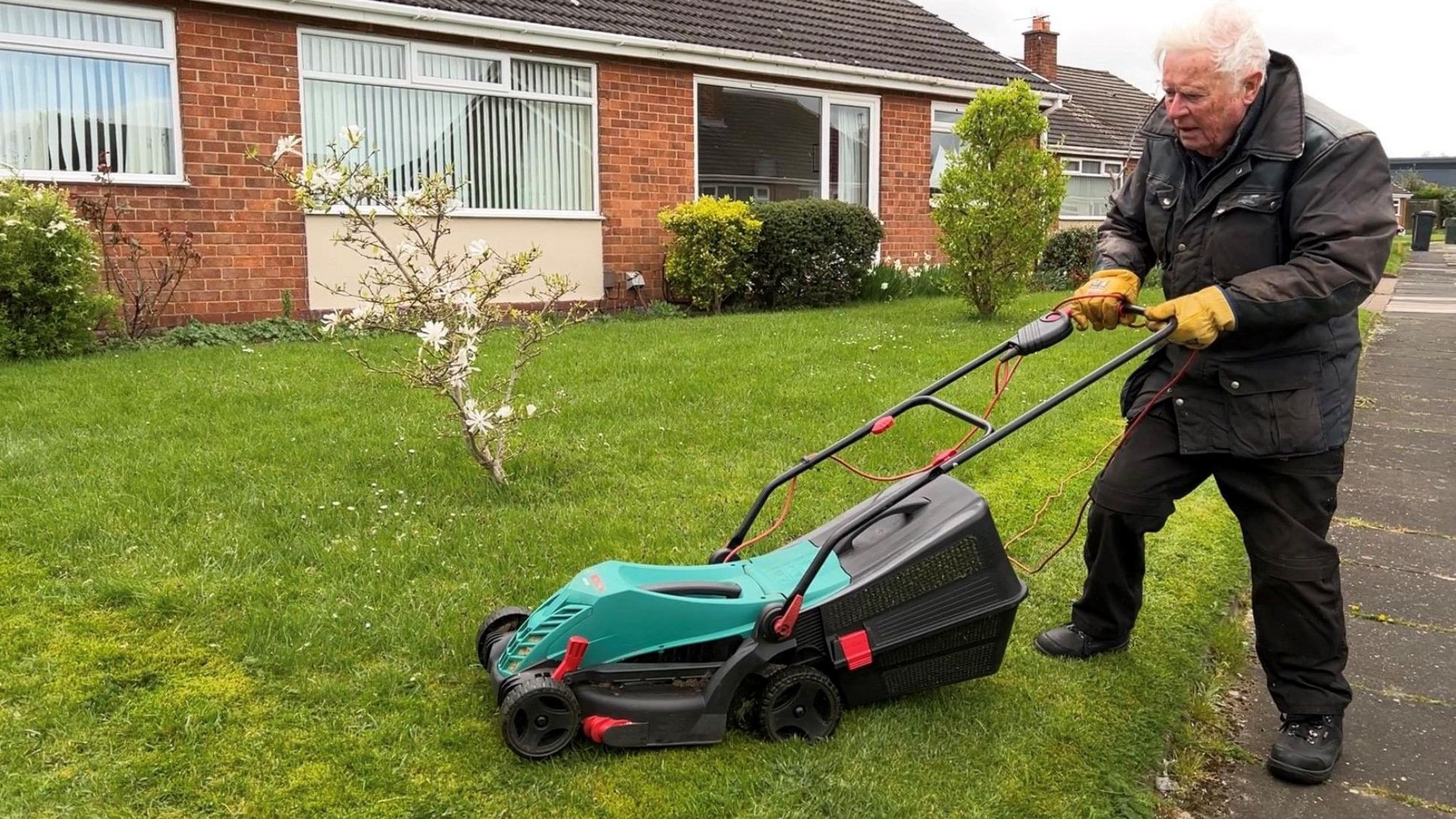 Howard Duddles mows his lawn