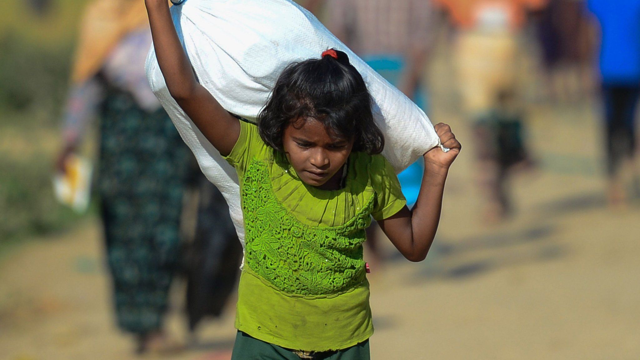 A refugee child carries aid in the Ukhia district of Bangladesh.