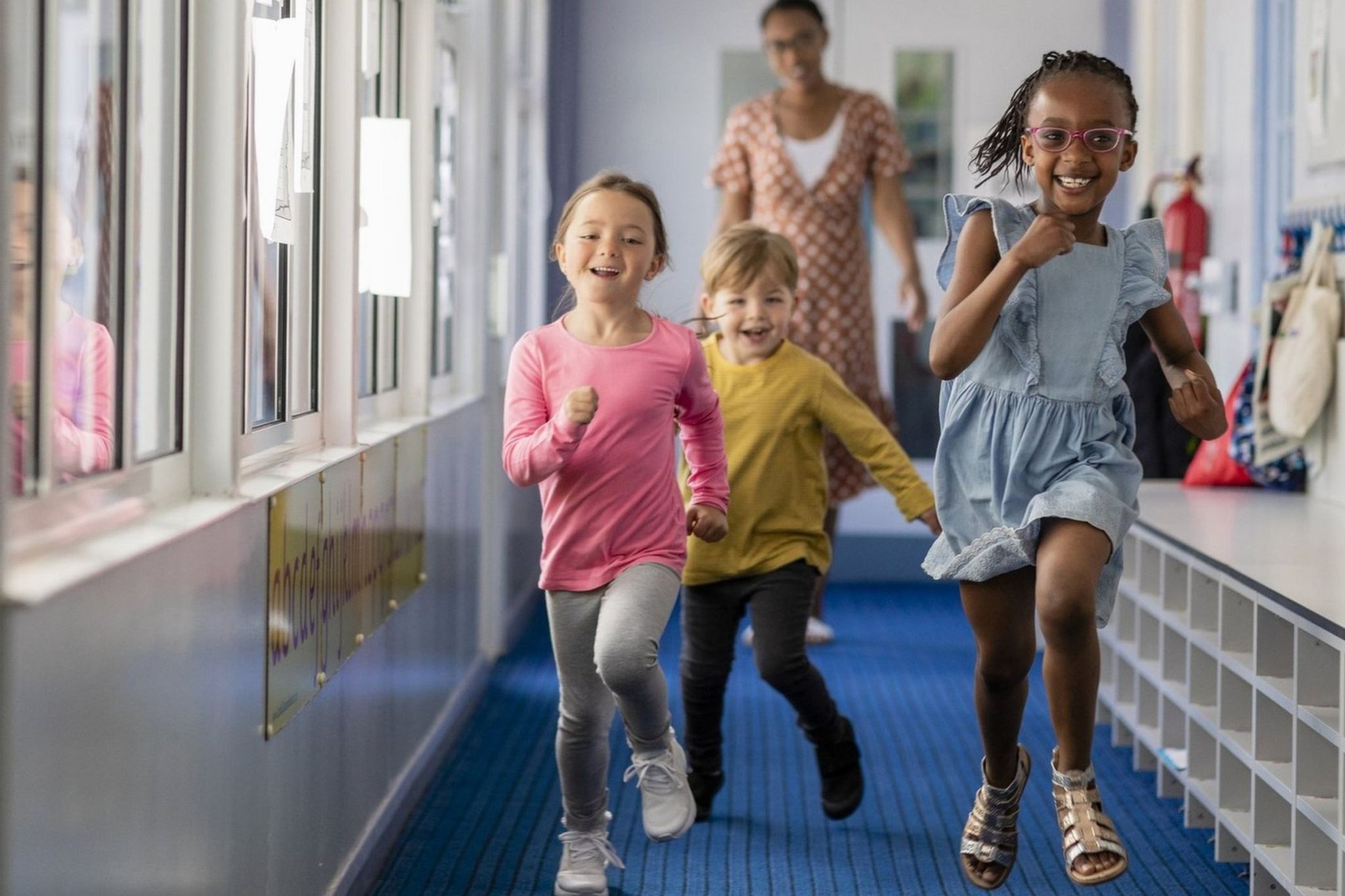 Pre-school children running through a hallway