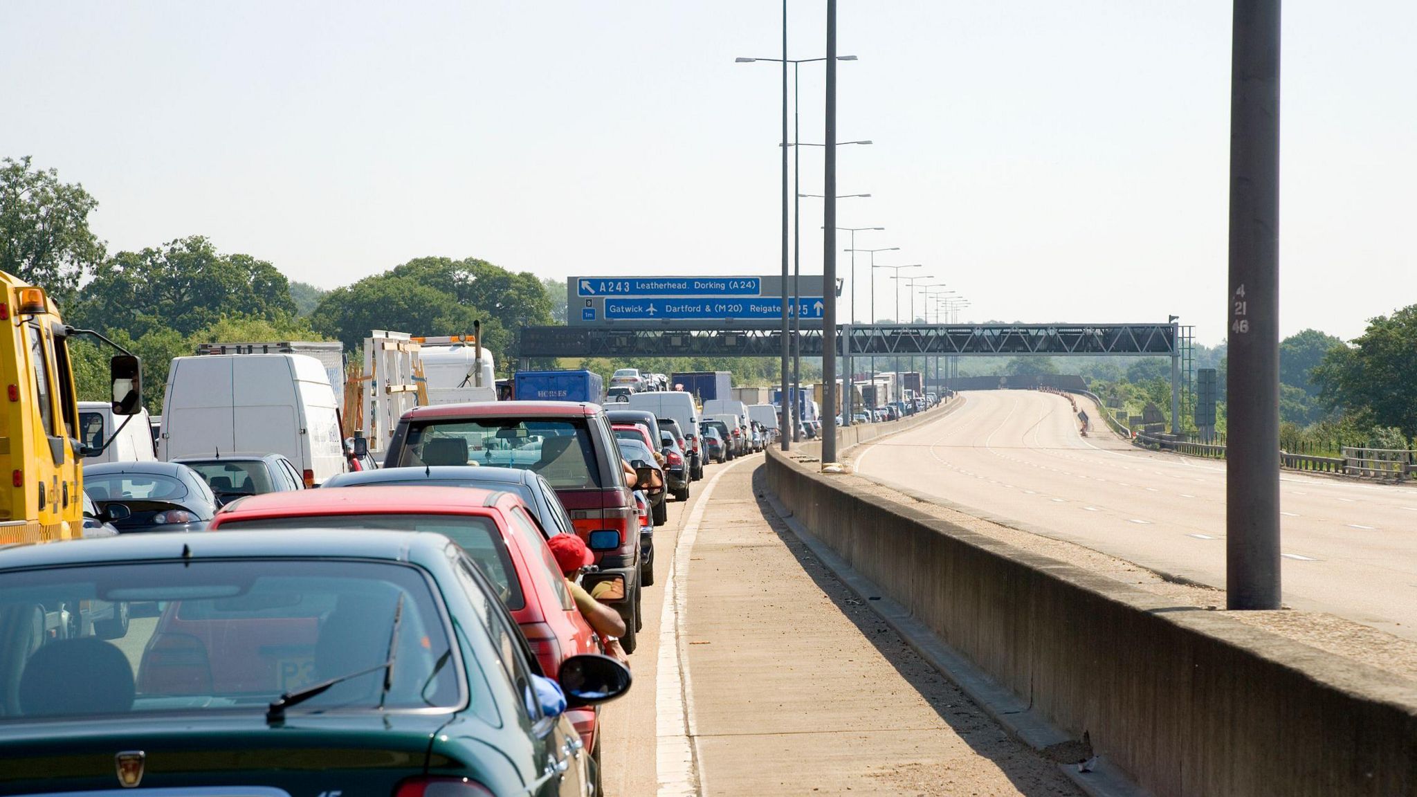 Cars queueing in traffic on one side of the M25, while the motorway in the other direction is empty