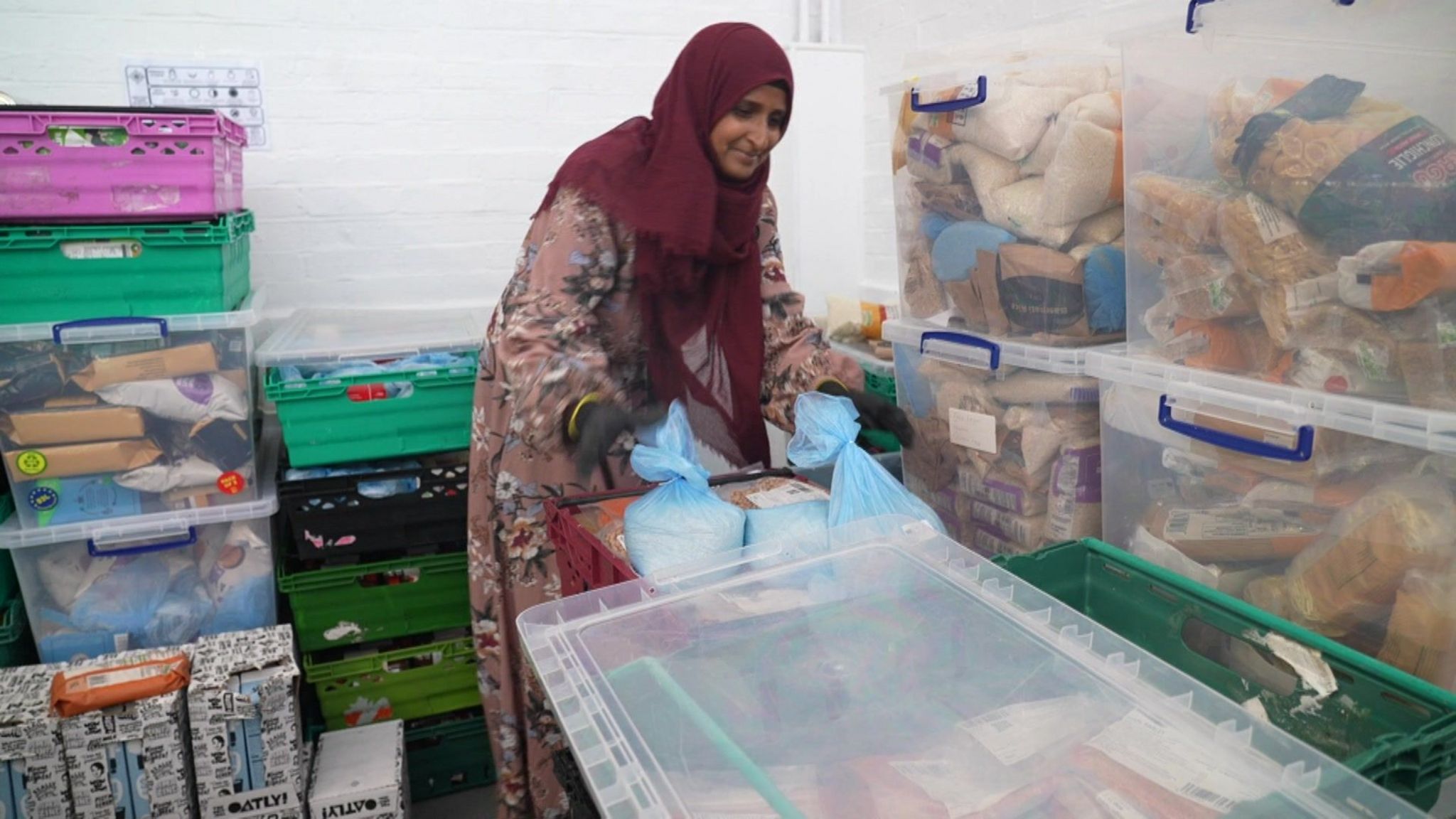 Woman sorting through large plastic boxes of food